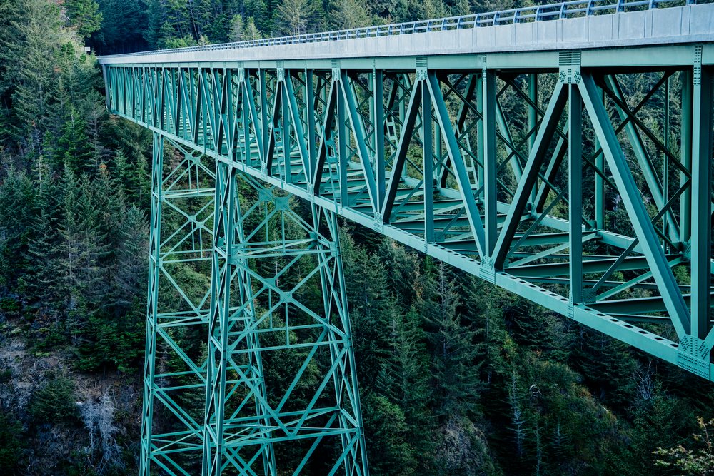 Green steel truss bridge above forest, Oregon