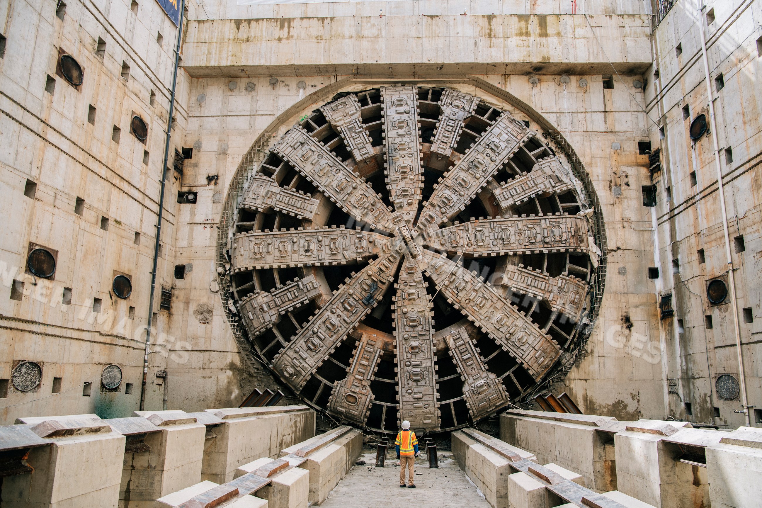 A construction white worker inspects a large tunnel boring machine