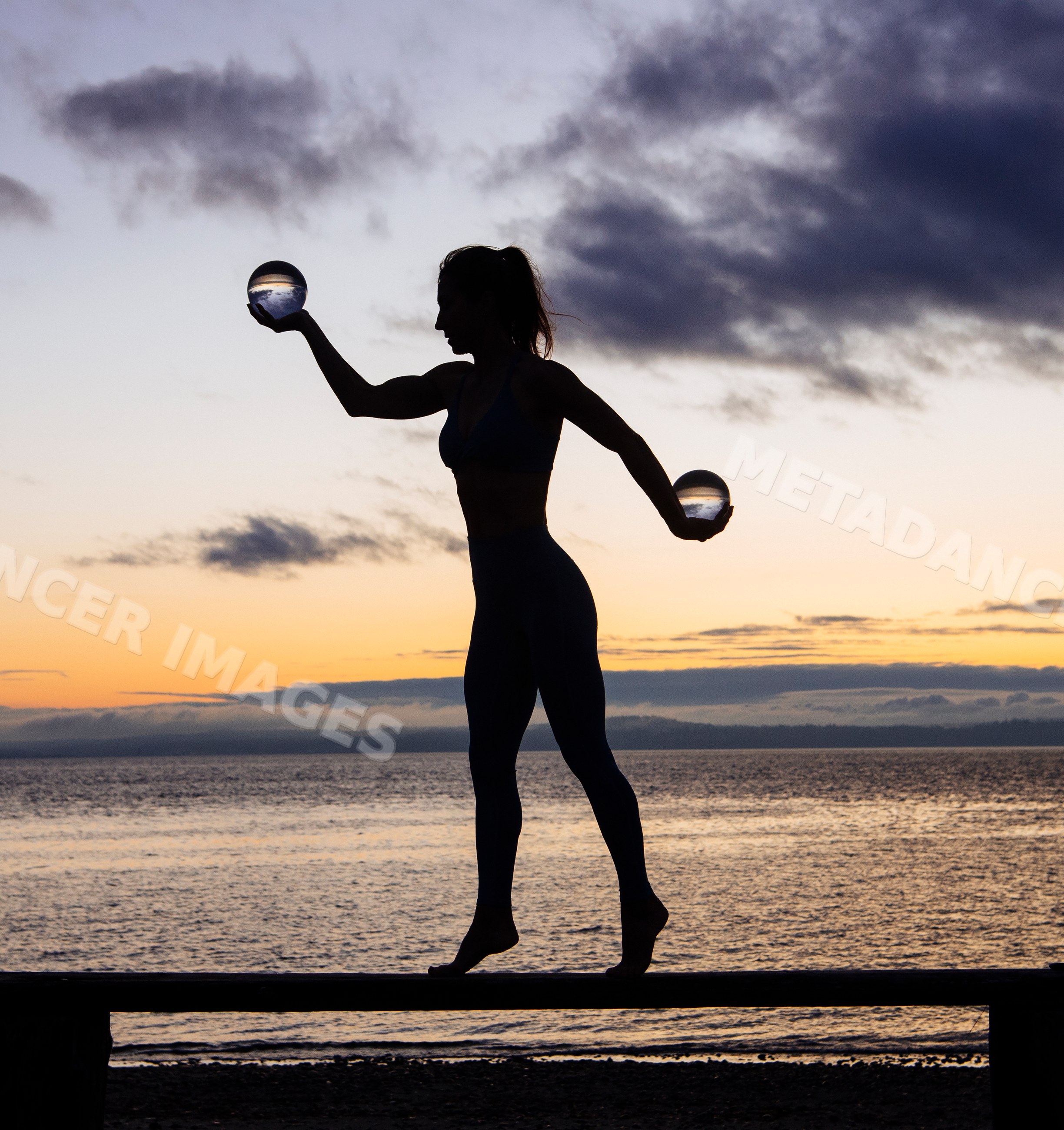 White woman silhouette balancing with crystal balls at beach sunset