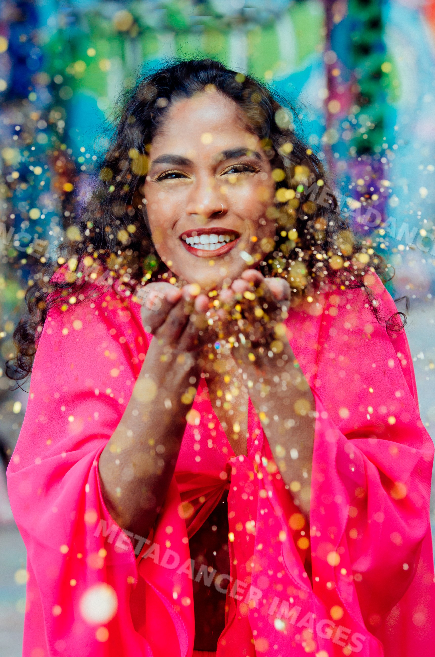 South Asian woman blowing glitter