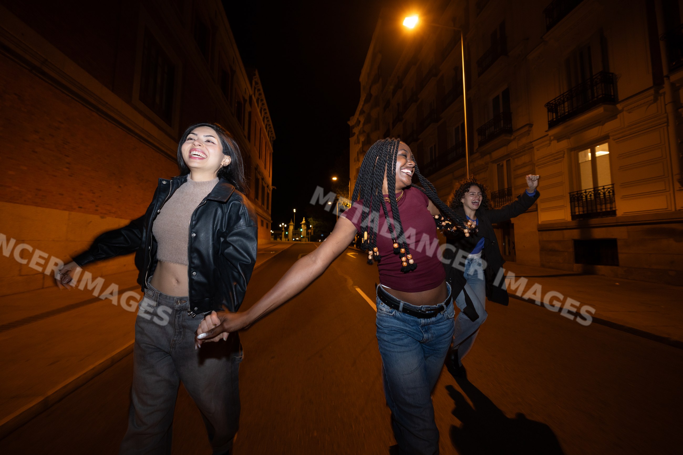 Three Hispanic, white and Black women laughing and holding hands