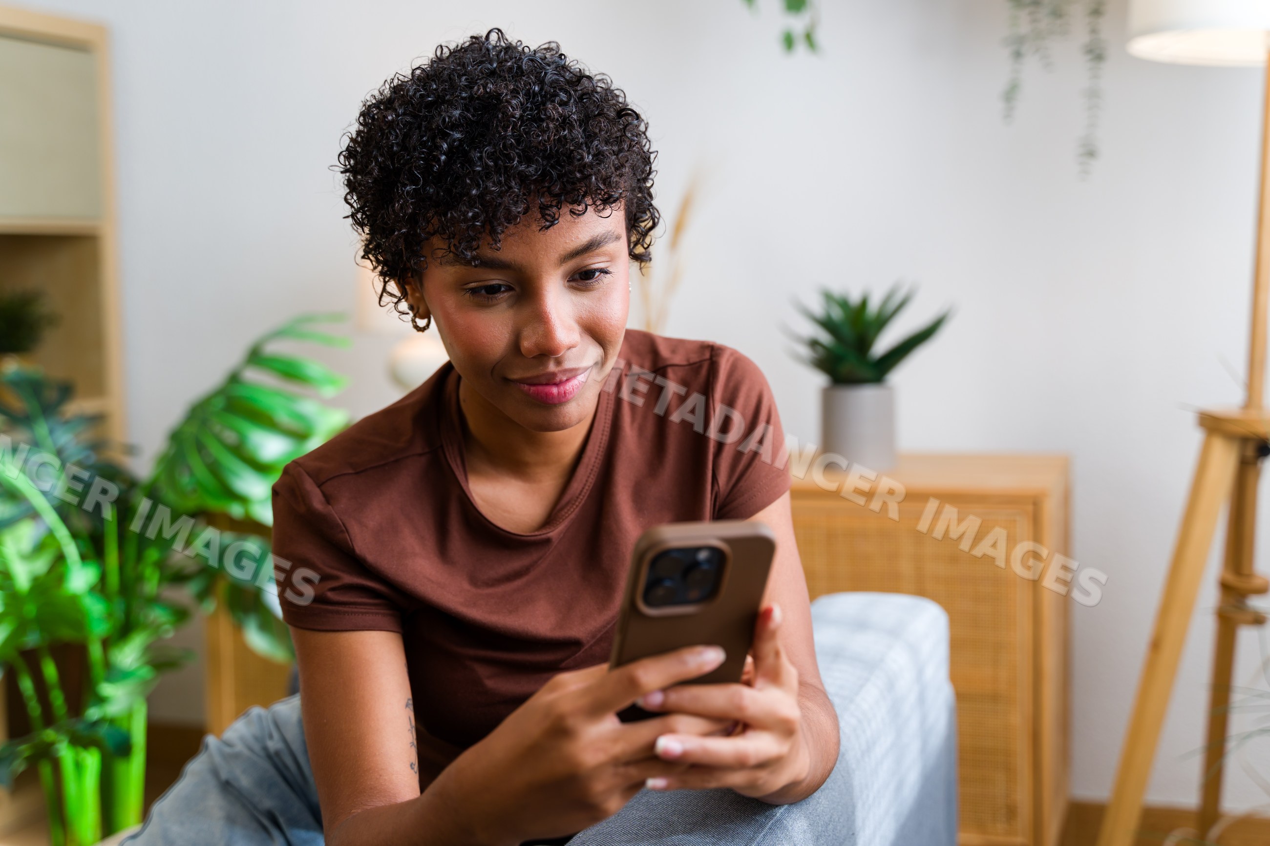 Young African American woman using smartphone indoors