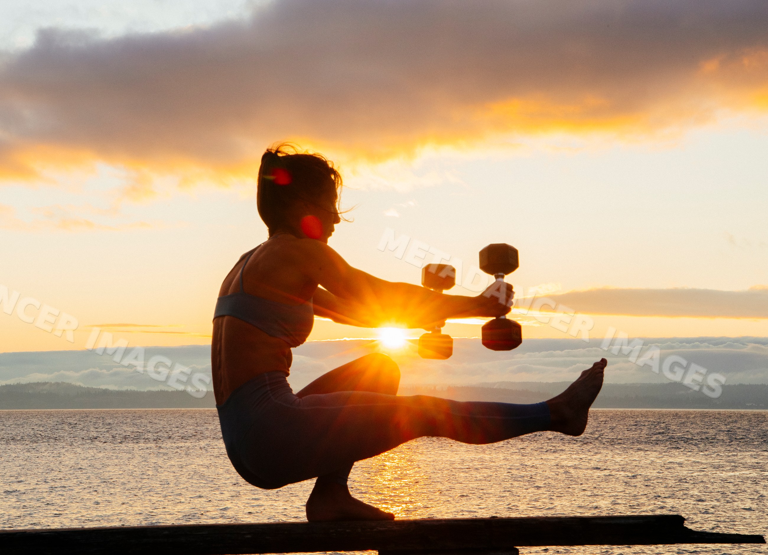 White woman exercising with dumbbells balancing squat pose