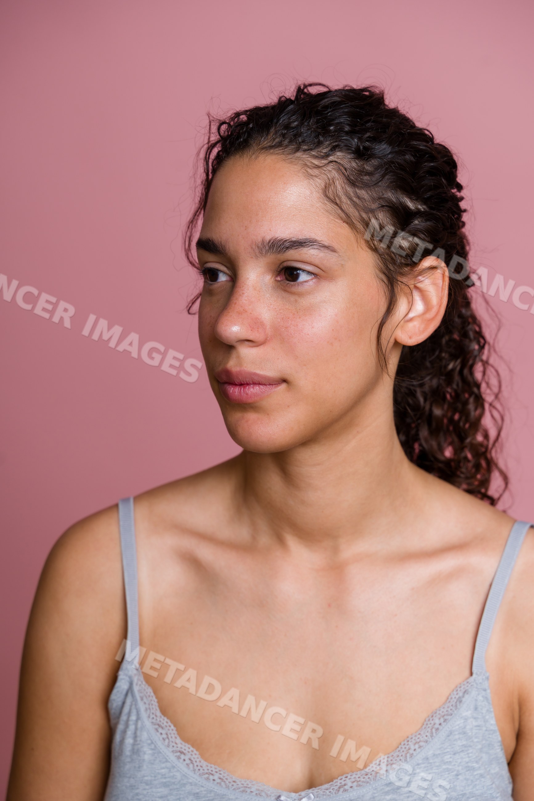 Hispanic woman with curly hair and natural skin in beauty studio