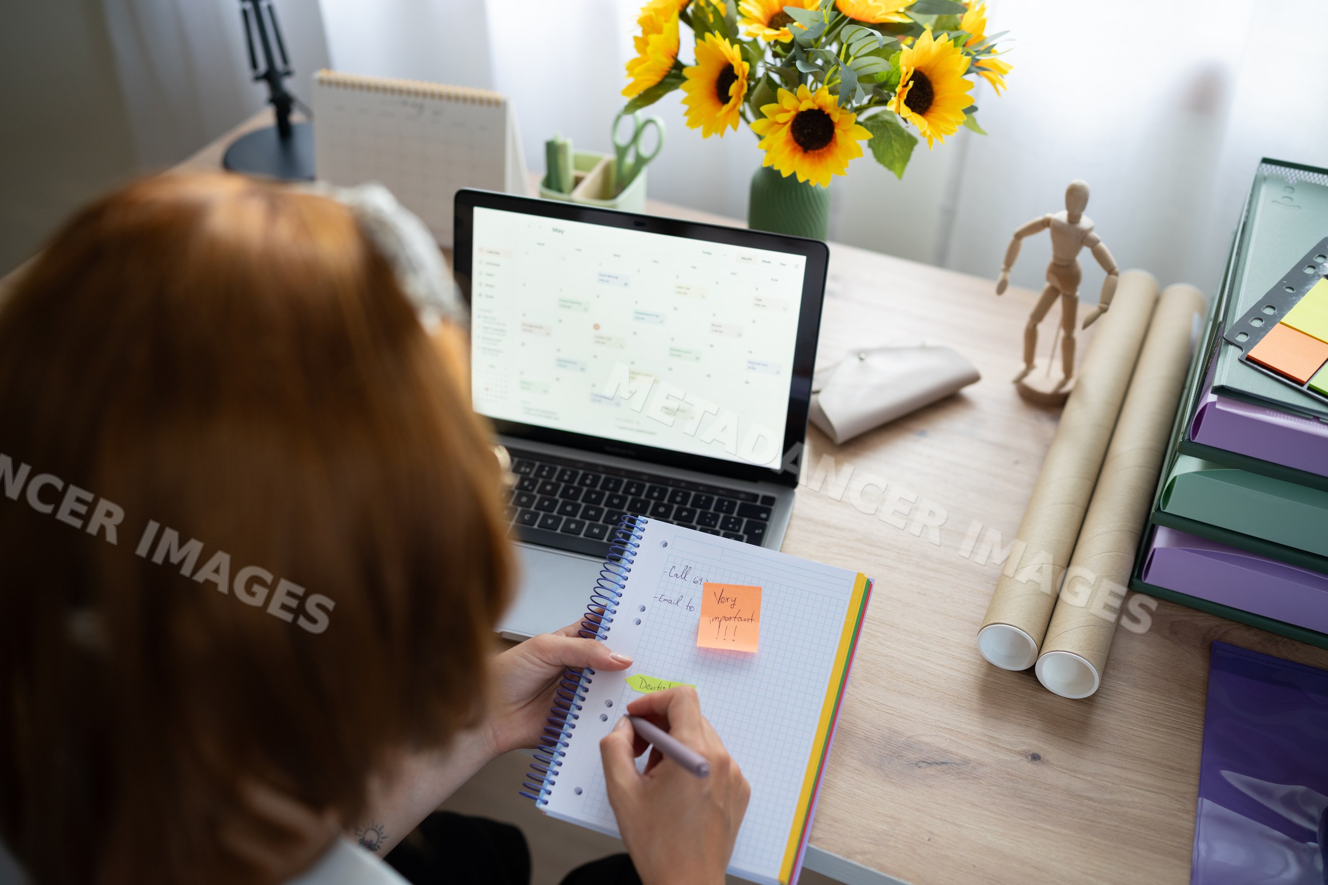 A white woman organizes her schedule from a laptop calendar