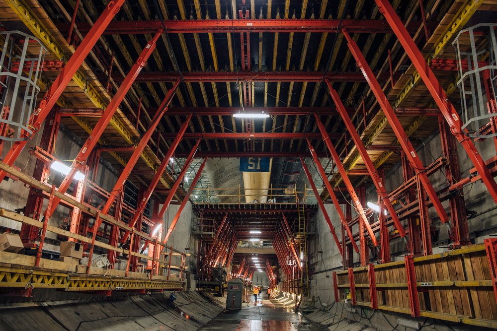Construction workers inside an underground tunnel with scaffolding