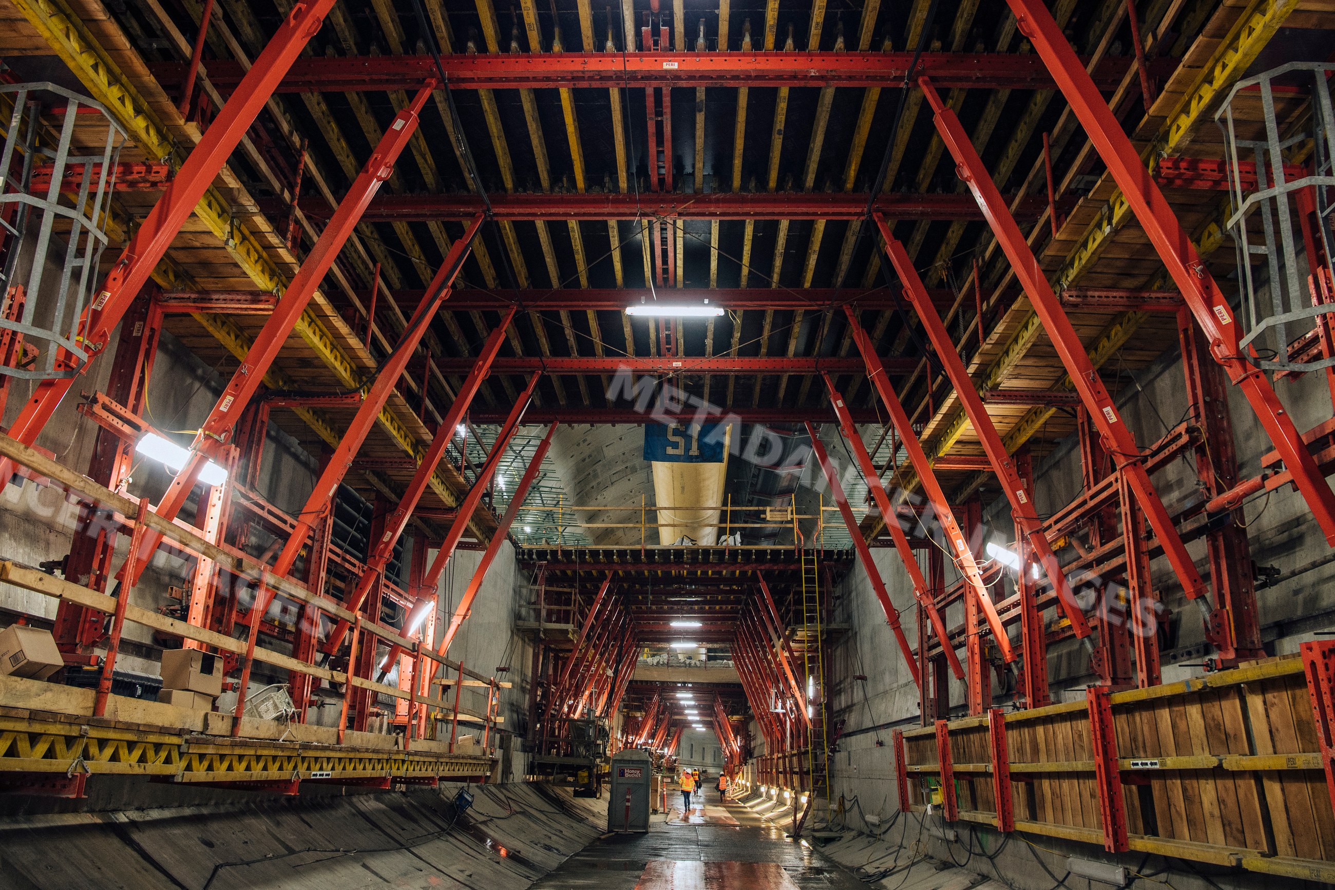 Construction workers inside an underground tunnel with scaffolding