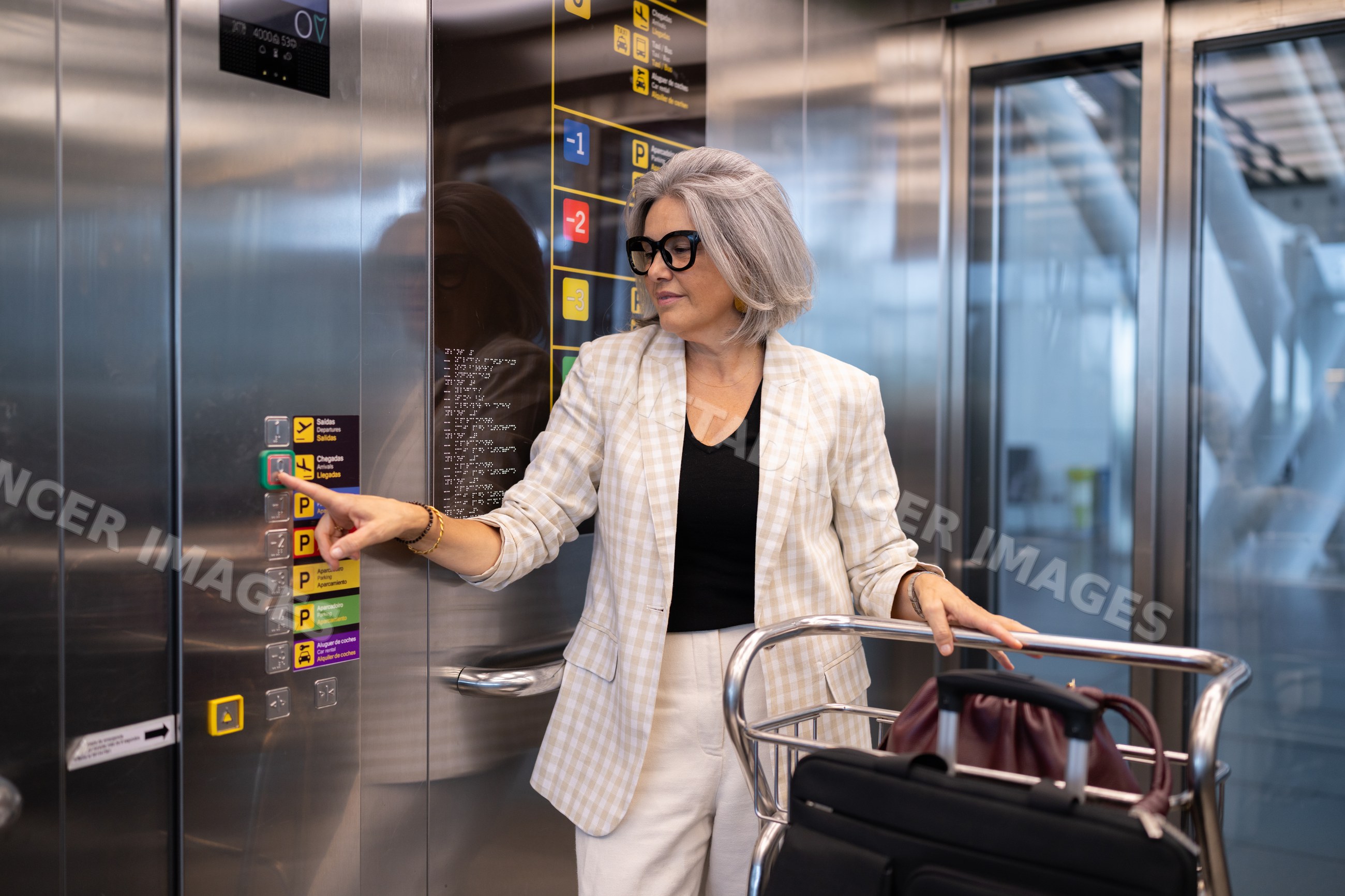White woman traveler pushing elevator button in a modern airport
