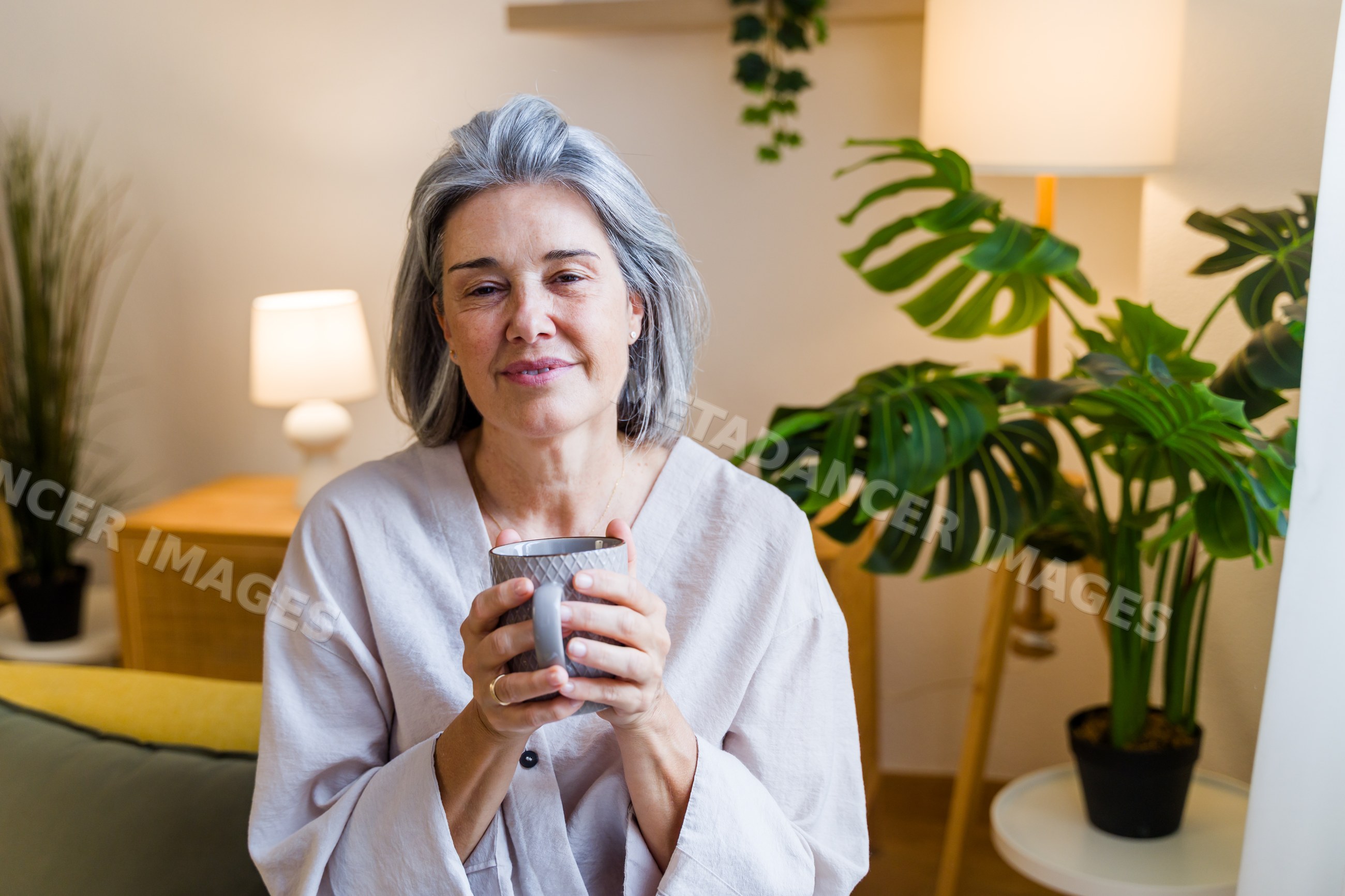 Mature white woman holding mug and relaxing