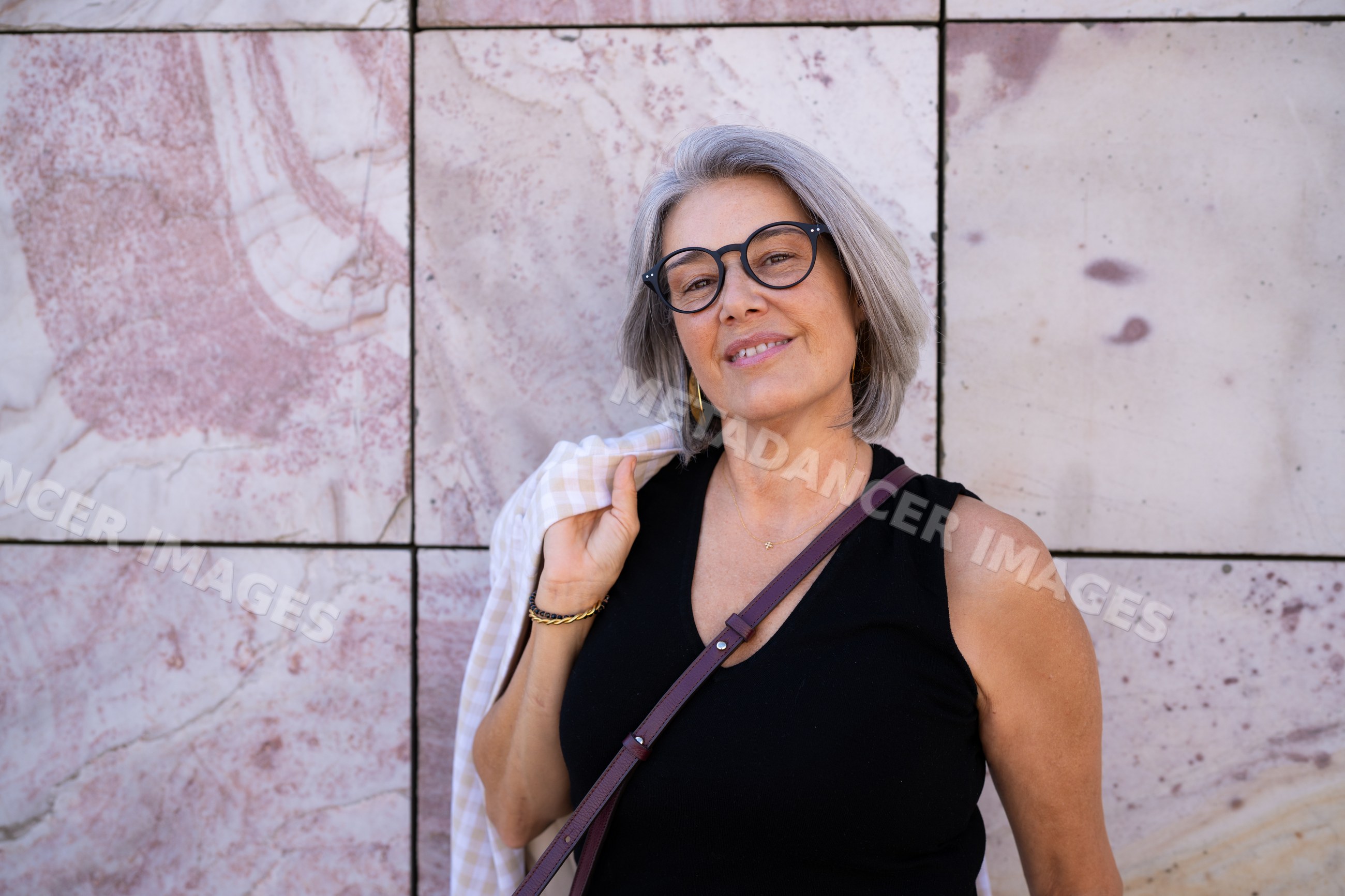 Portrait of a confident white woman with gray hair and glasses against