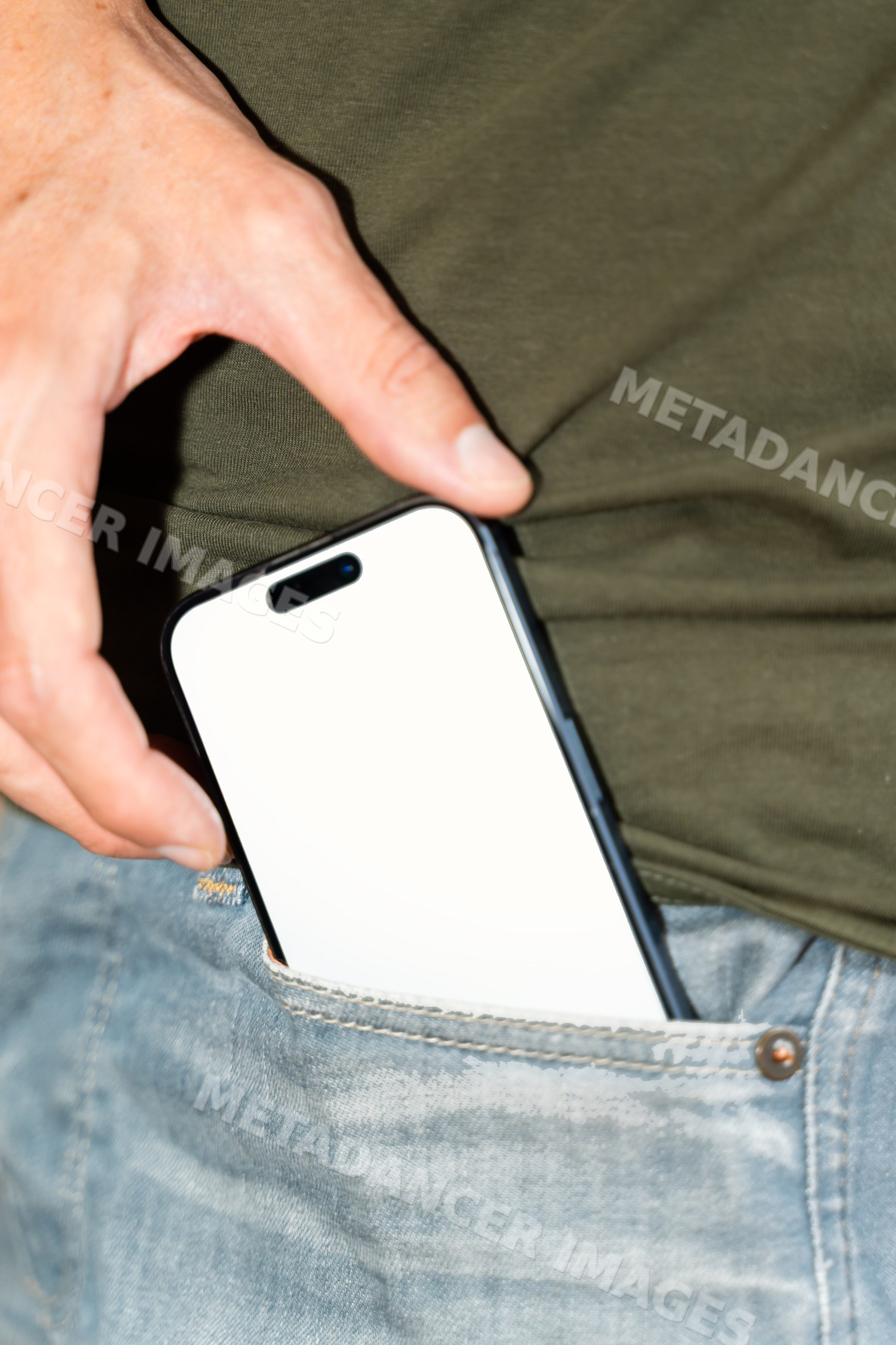 White person putting smartphone into front pocket of blue jeans