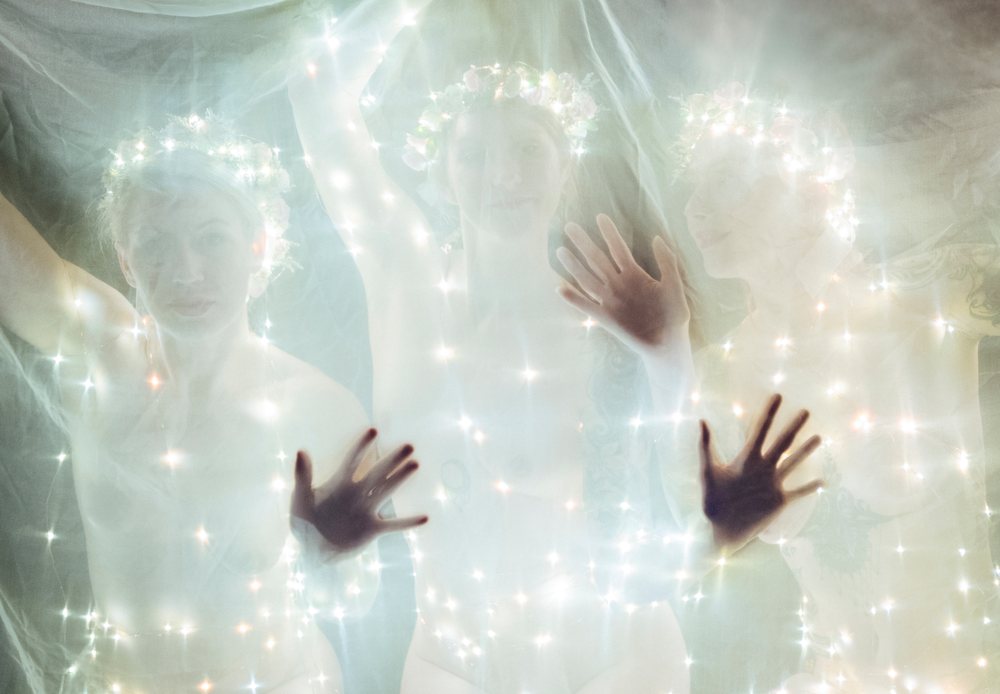 Three white women with glowing lights in artistic mystical portrait