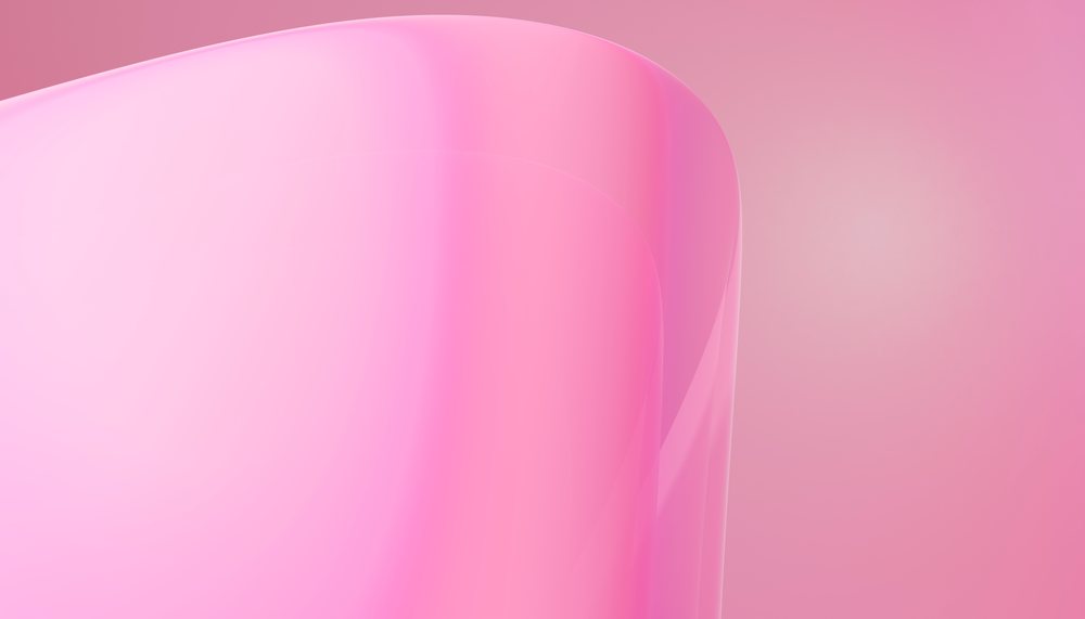 Close-up of a glossy transparent pink curved surface with soft