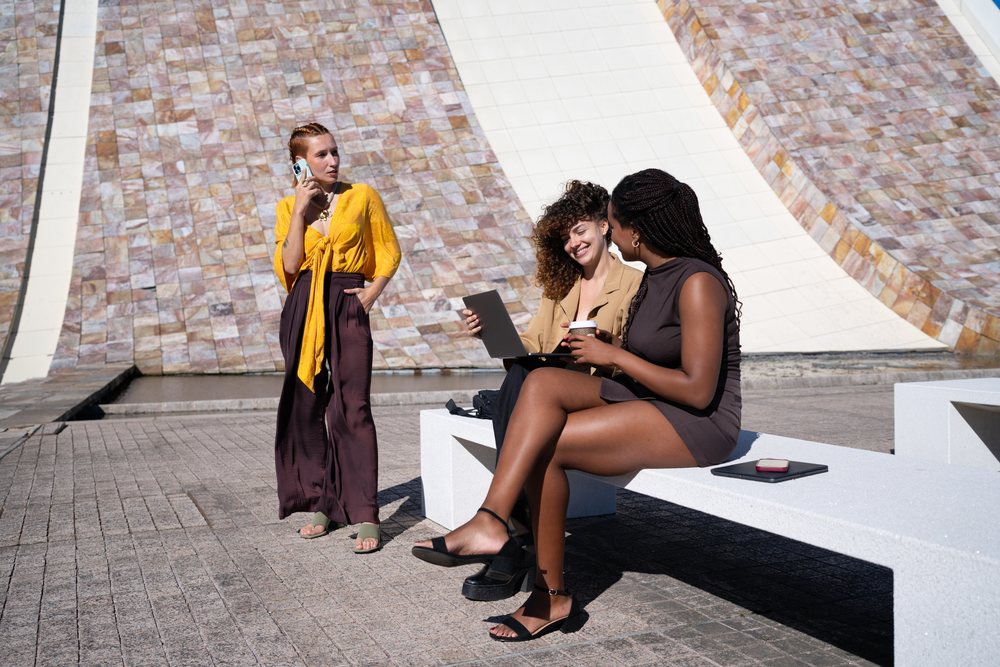 Three African American and white women socializing outdoors