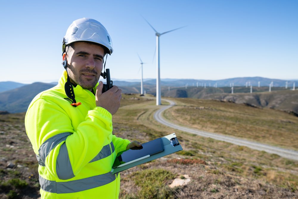 Engineer using radio walkie talkie at wind farm in Galicia Spain