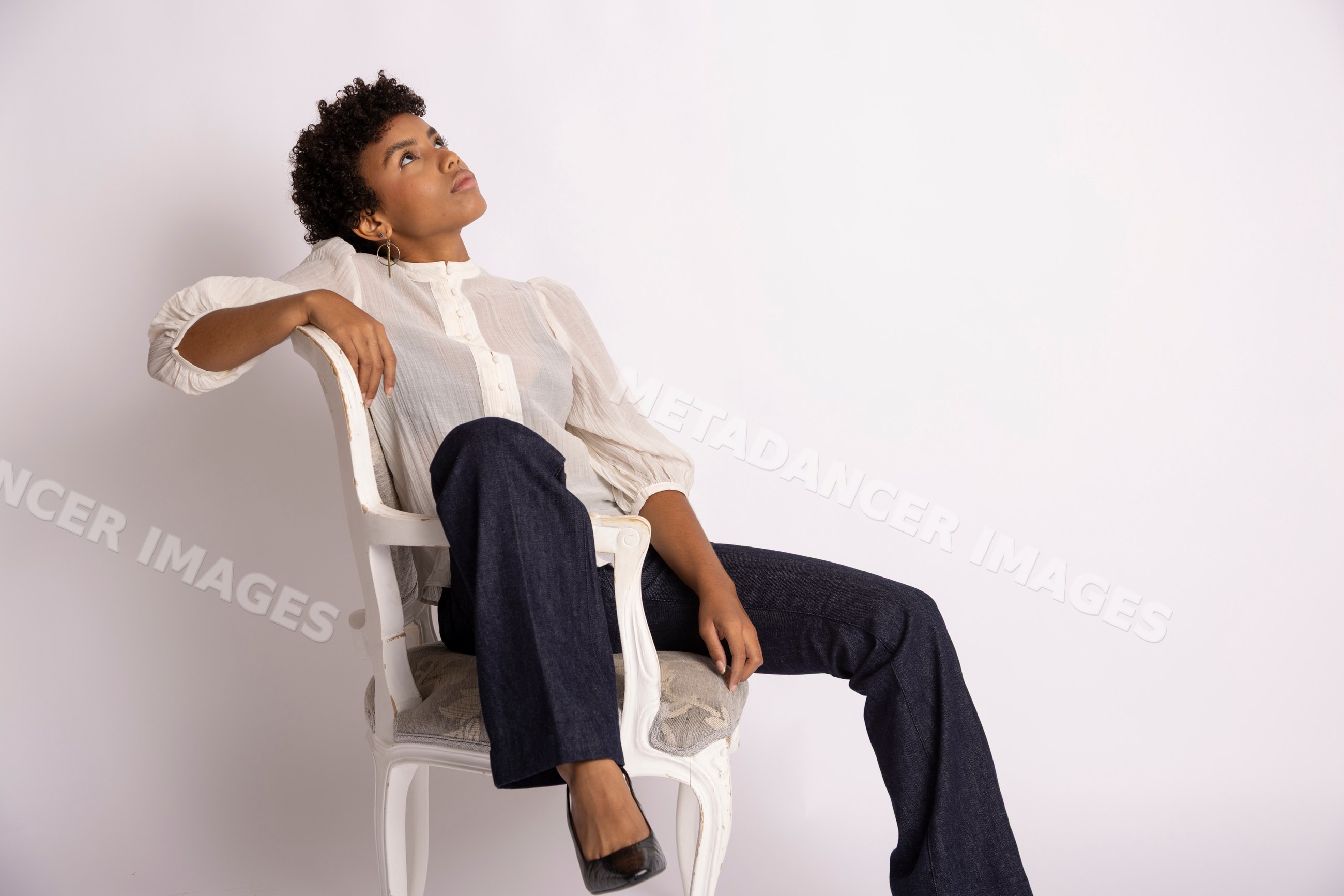 Hispanic woman sitting on a chair looking
