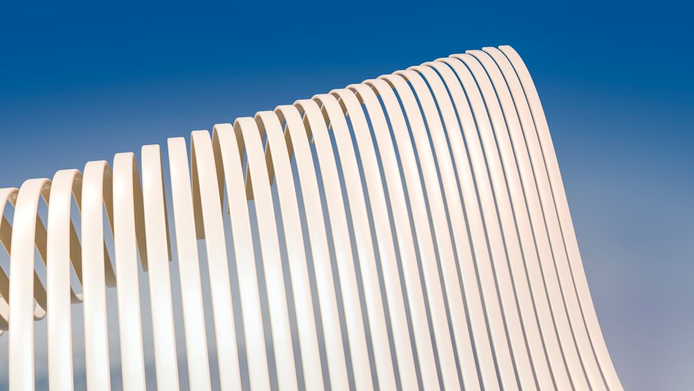 White modern abstract sculpture with curved lines against blue sky