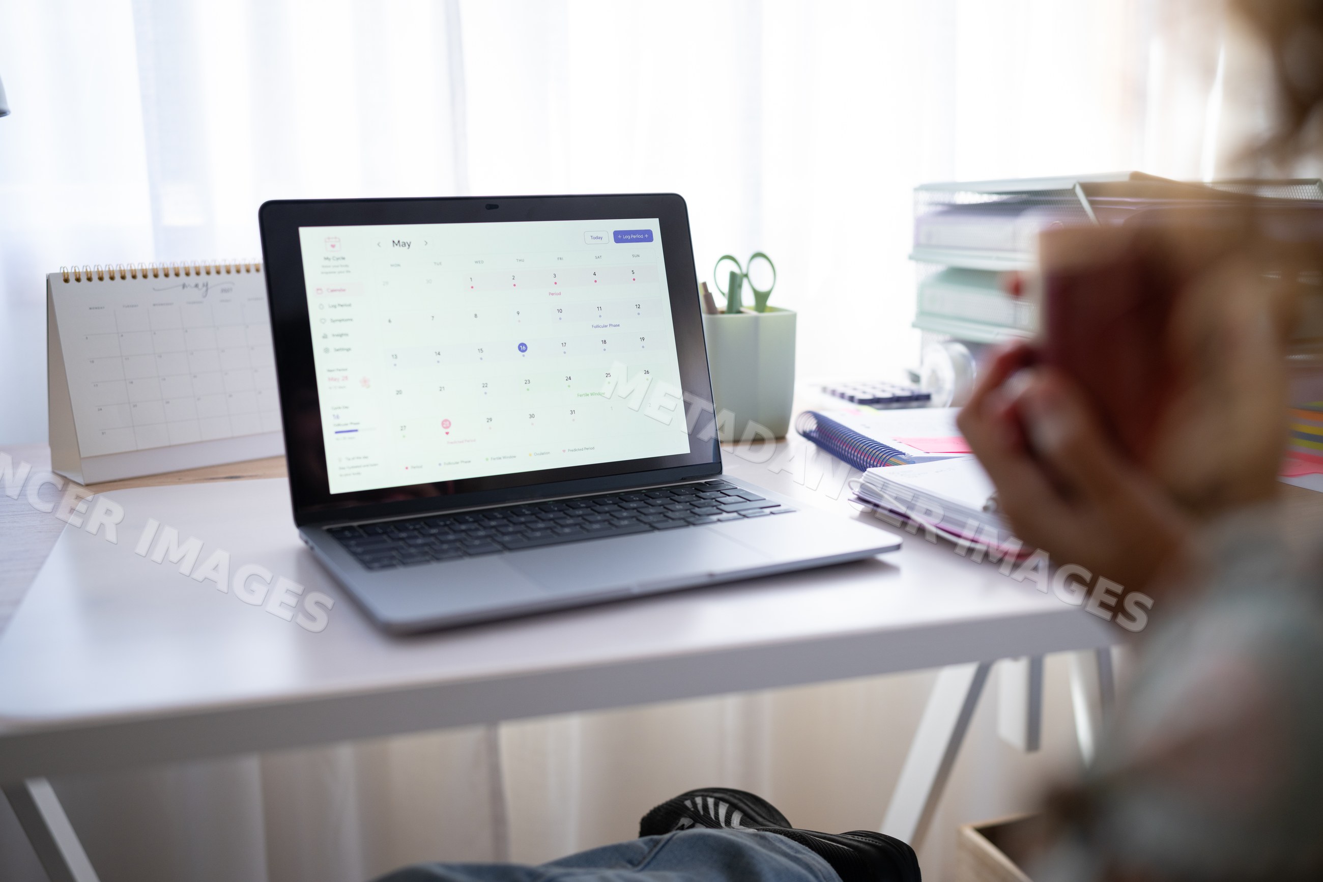 Laptop showing calendar on desk in home office setting