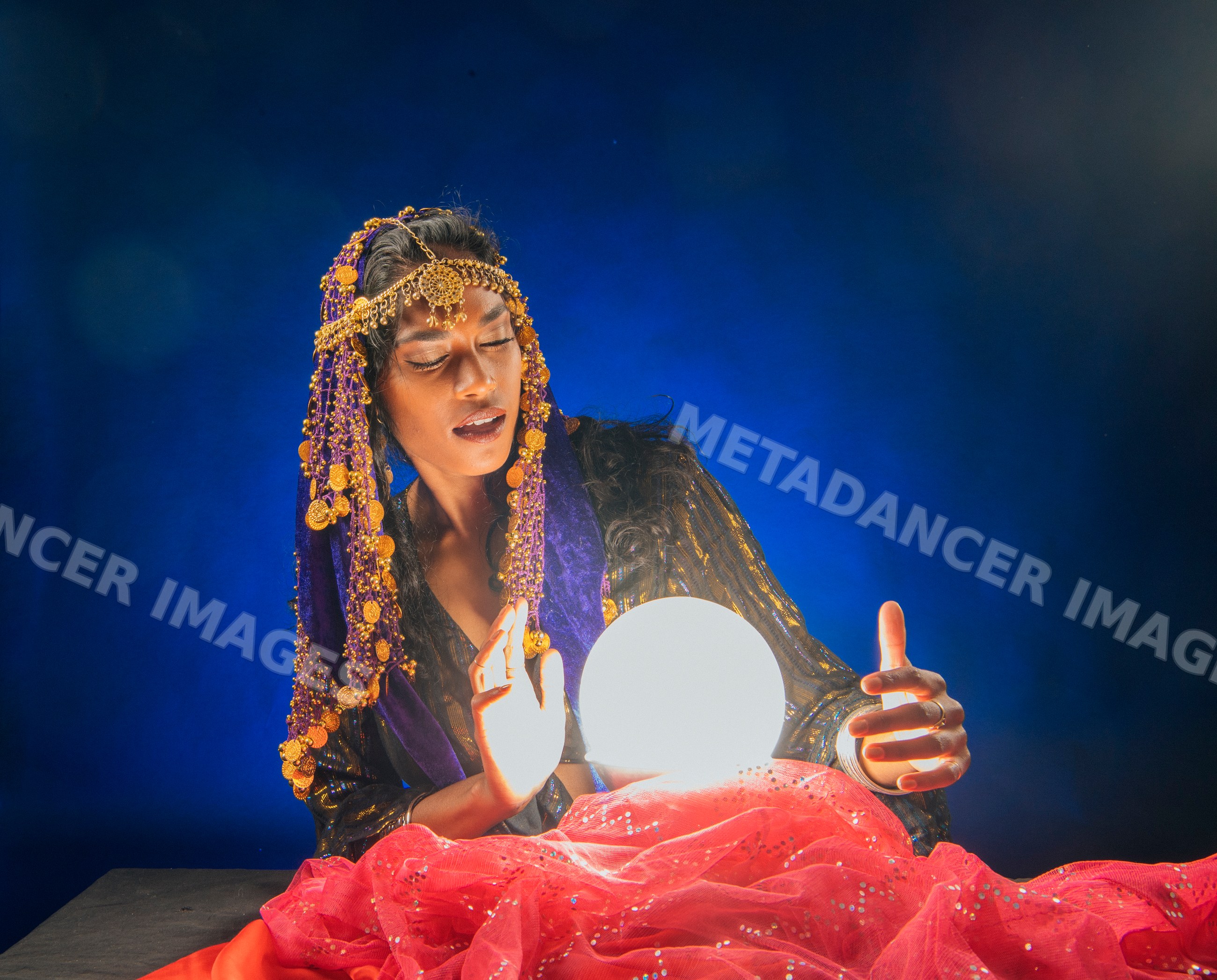 A fortune teller in traditional attire gazes into a glowing crystal