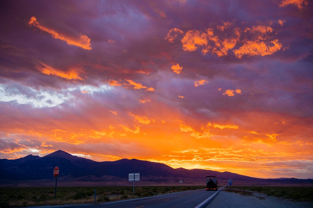 Sunset over Nevada mountain range with truck on desert highway