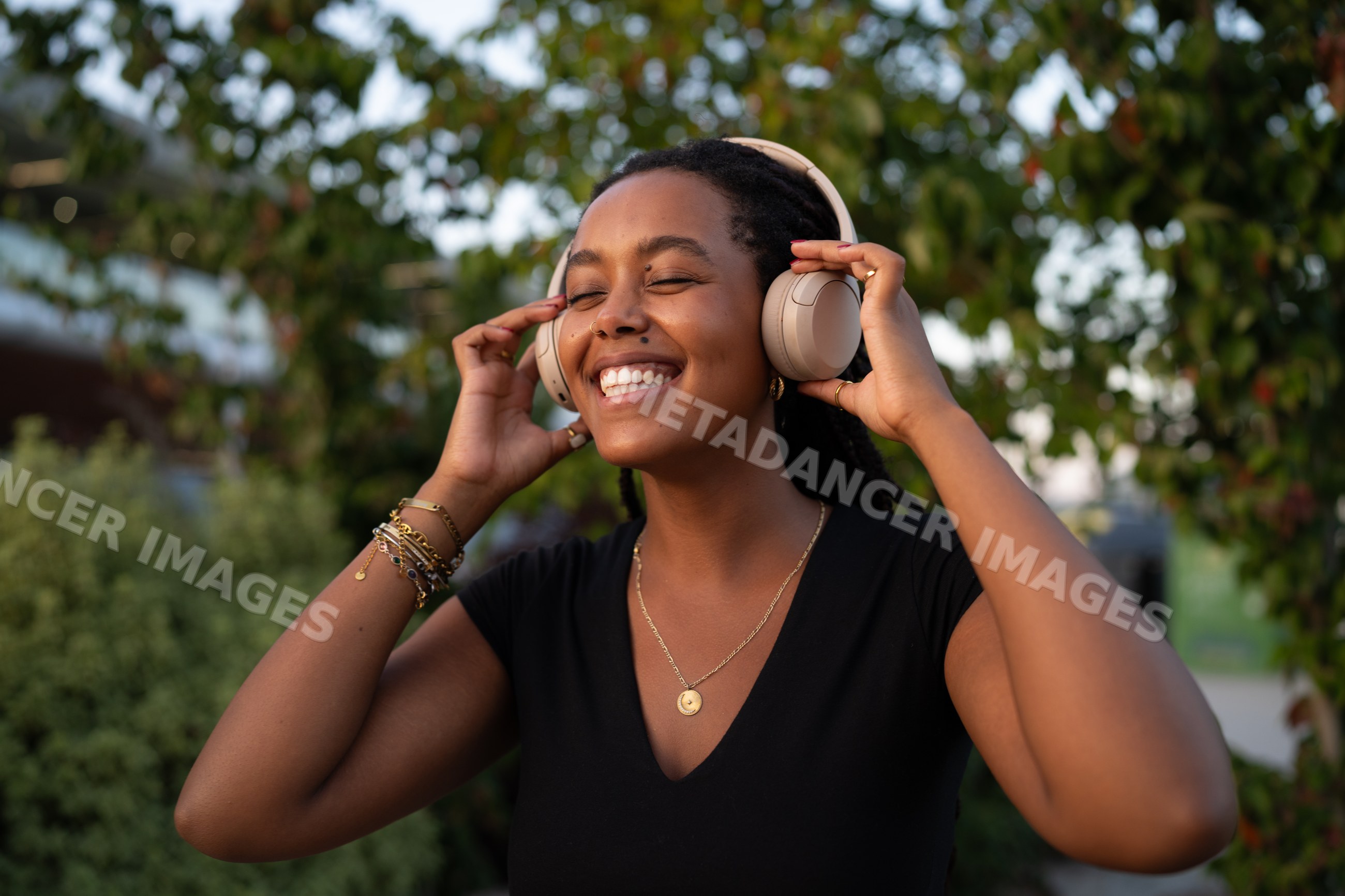 A African American woman enjoys music outdoors with headphones