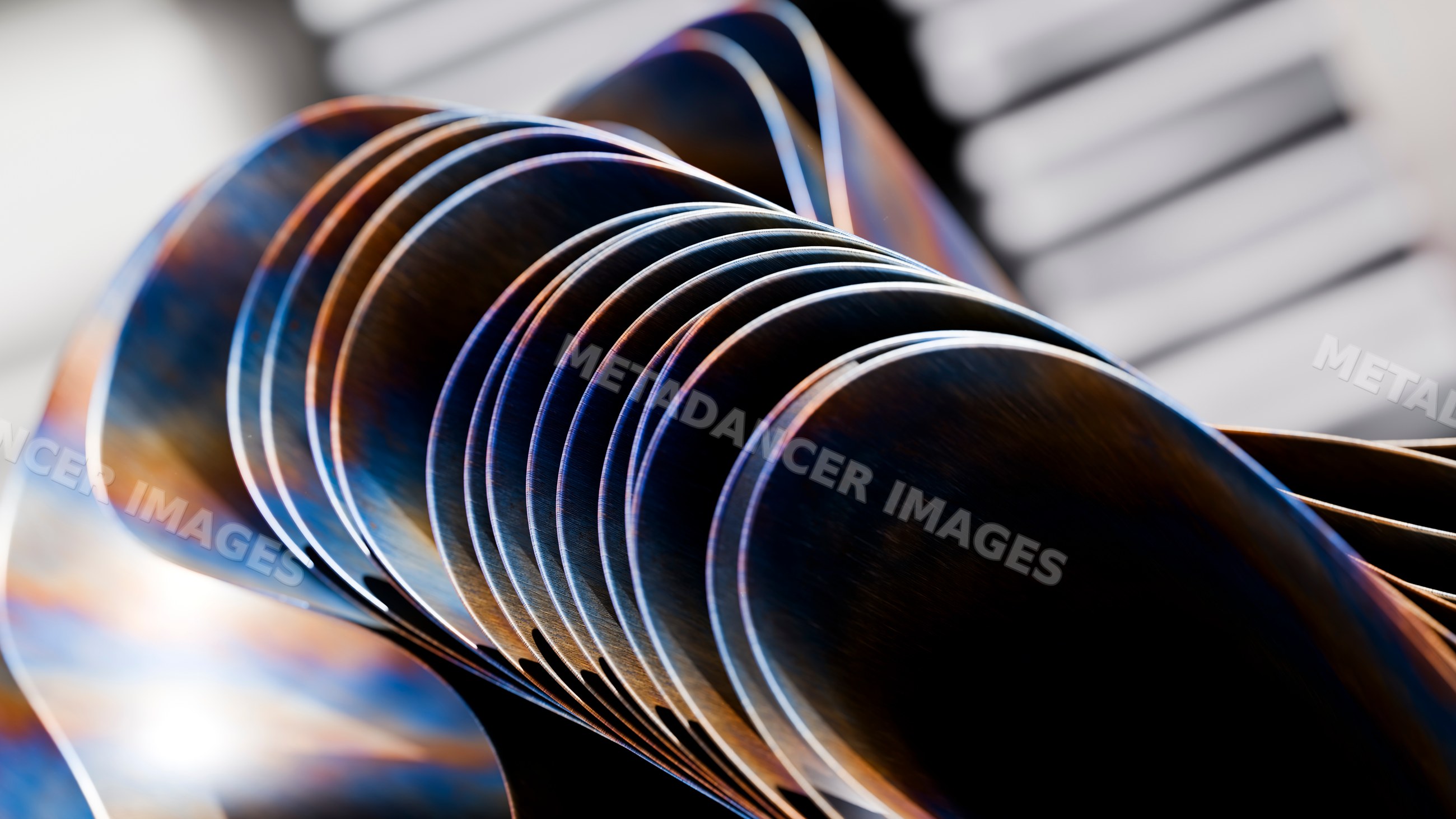 Row of metal spoons showing reflective curved surfaces