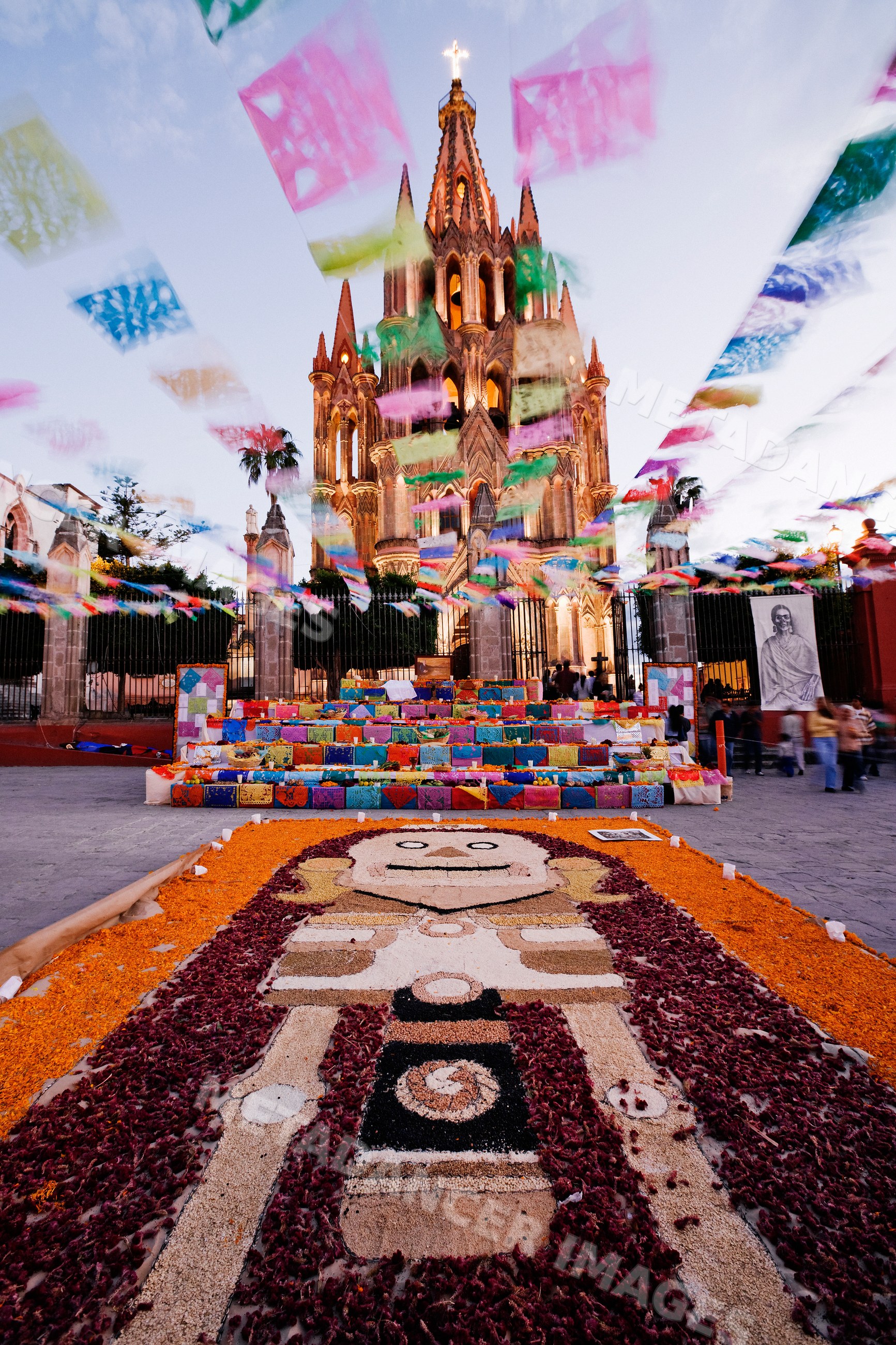 Altar decorated with flower petals and flags during day of the dead