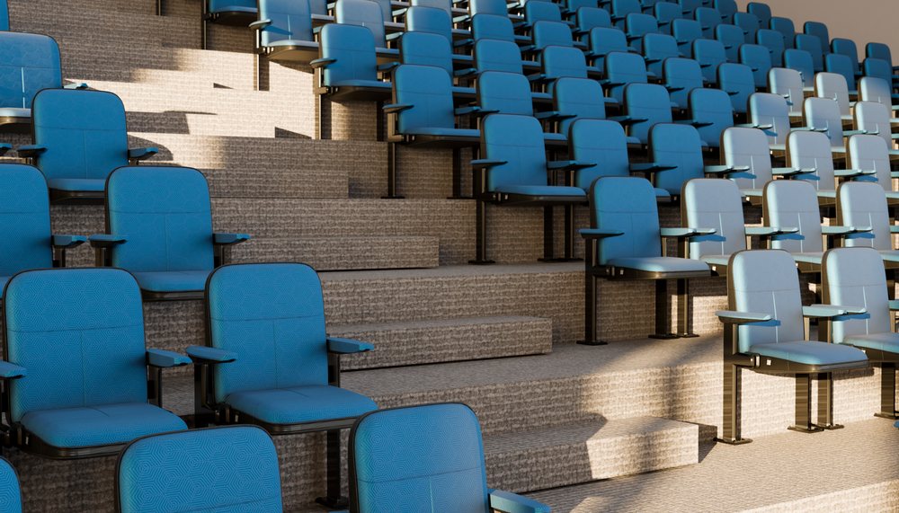 Rows of blue seats in tiered stadium-style auditorium seating