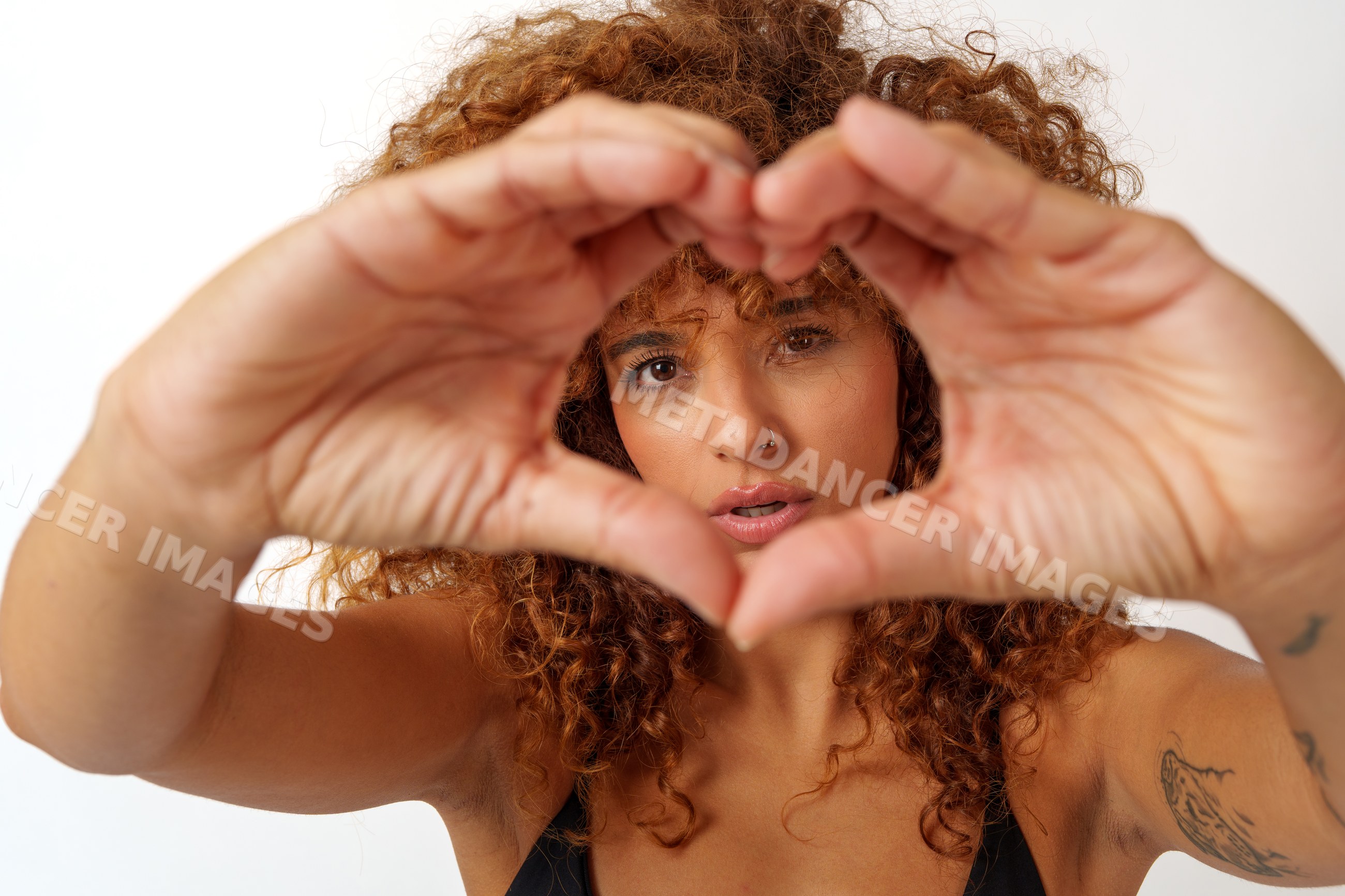 Hispanic woman making heart shape gesture with hands