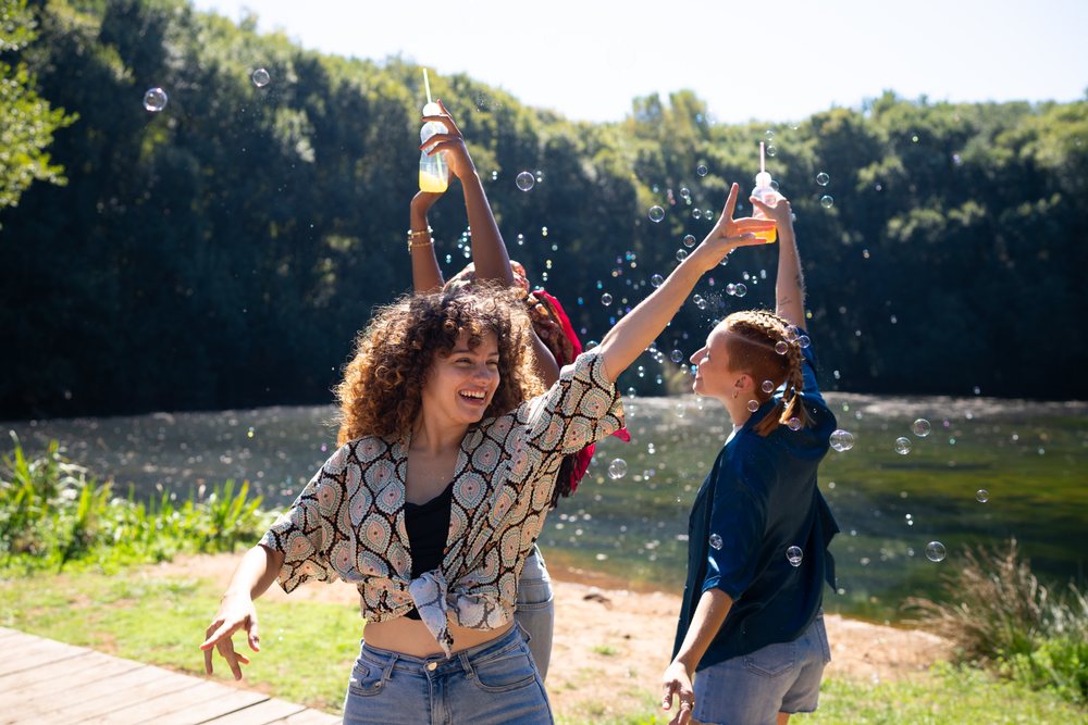 White and African American women celebrating with drinks and bubbles
