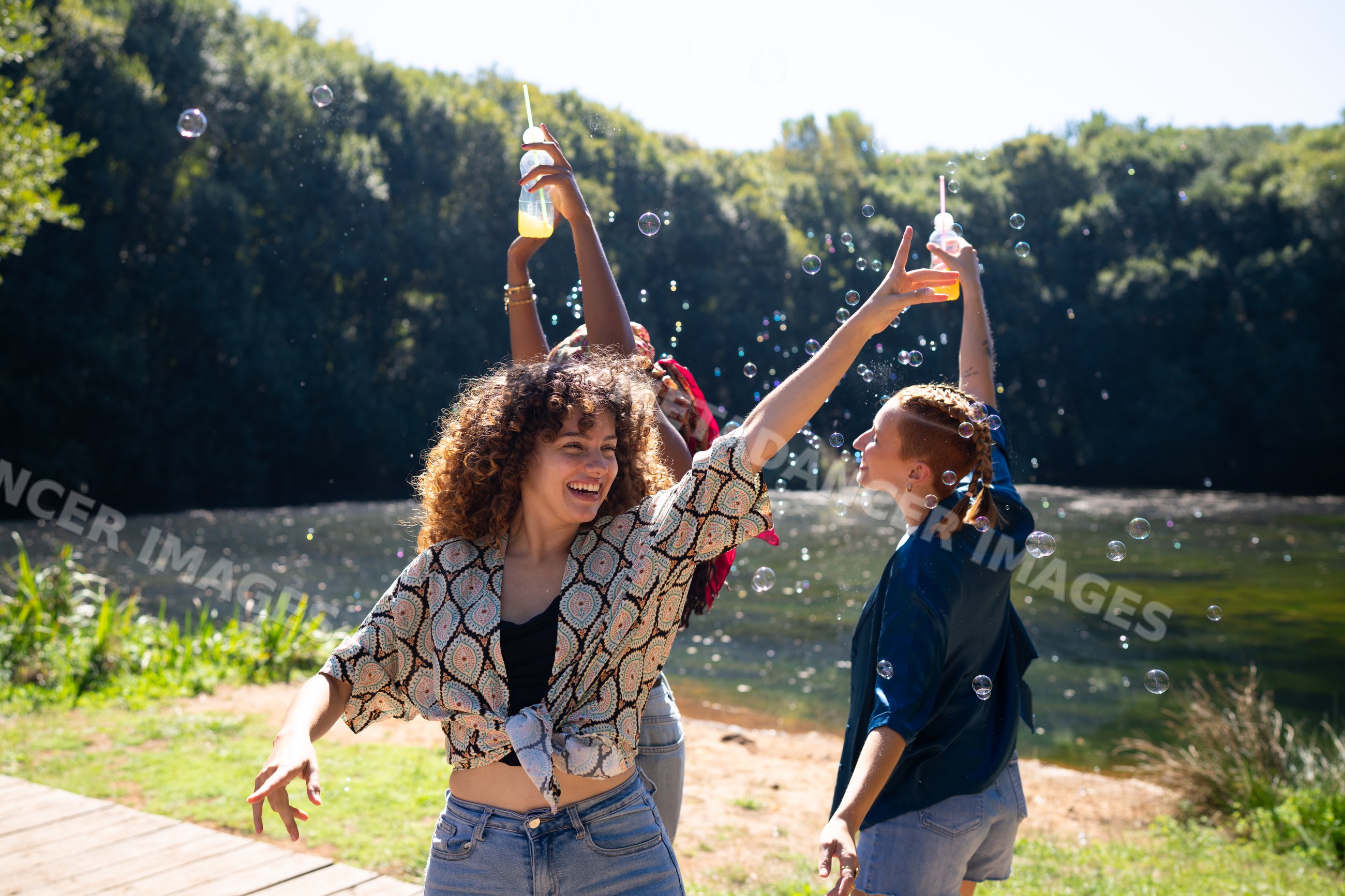 White and African American women celebrating with drinks and bubbles