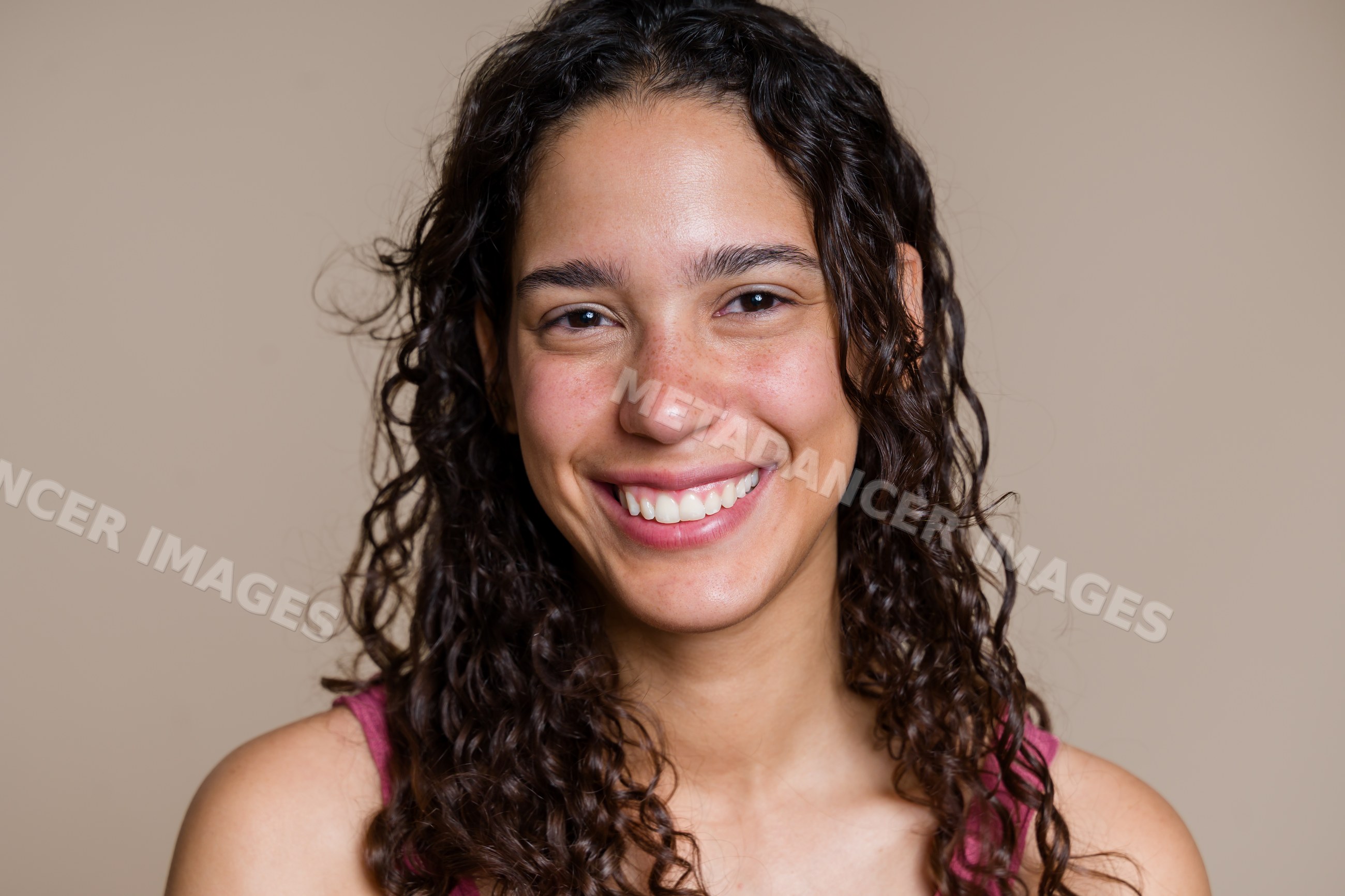 Portrait of a smiling Hispanic woman with curly hair