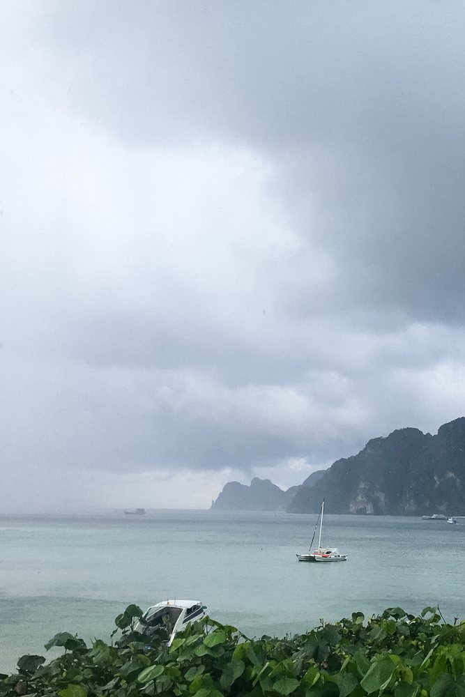 Stormy sea coastline in the Philippines with boats and island cliffs
