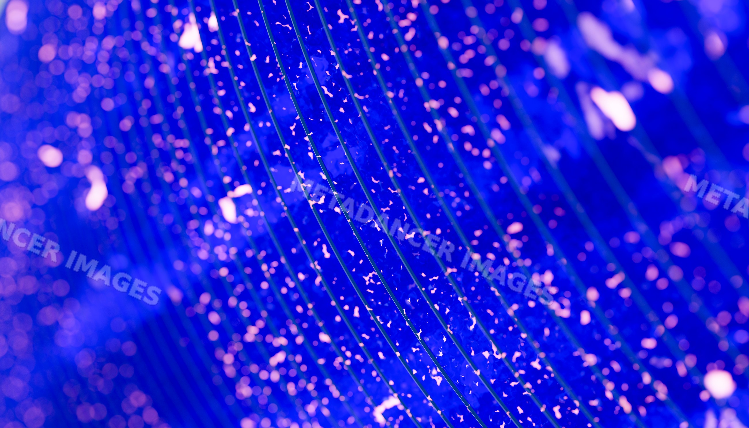 Close-up abstract pattern of glowing blue and pink dots with curved