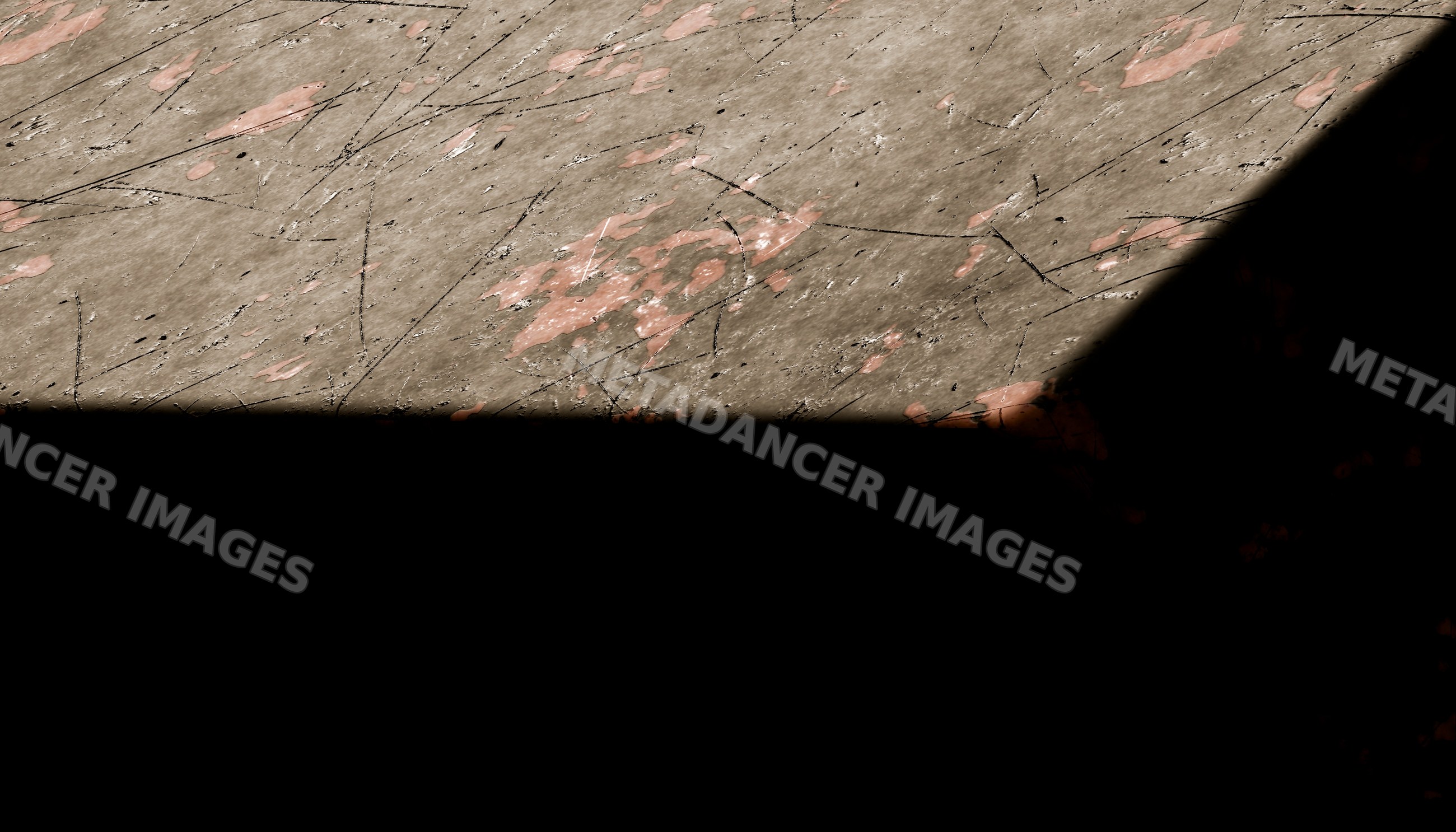 Worn concrete floor with paint spots and shadow