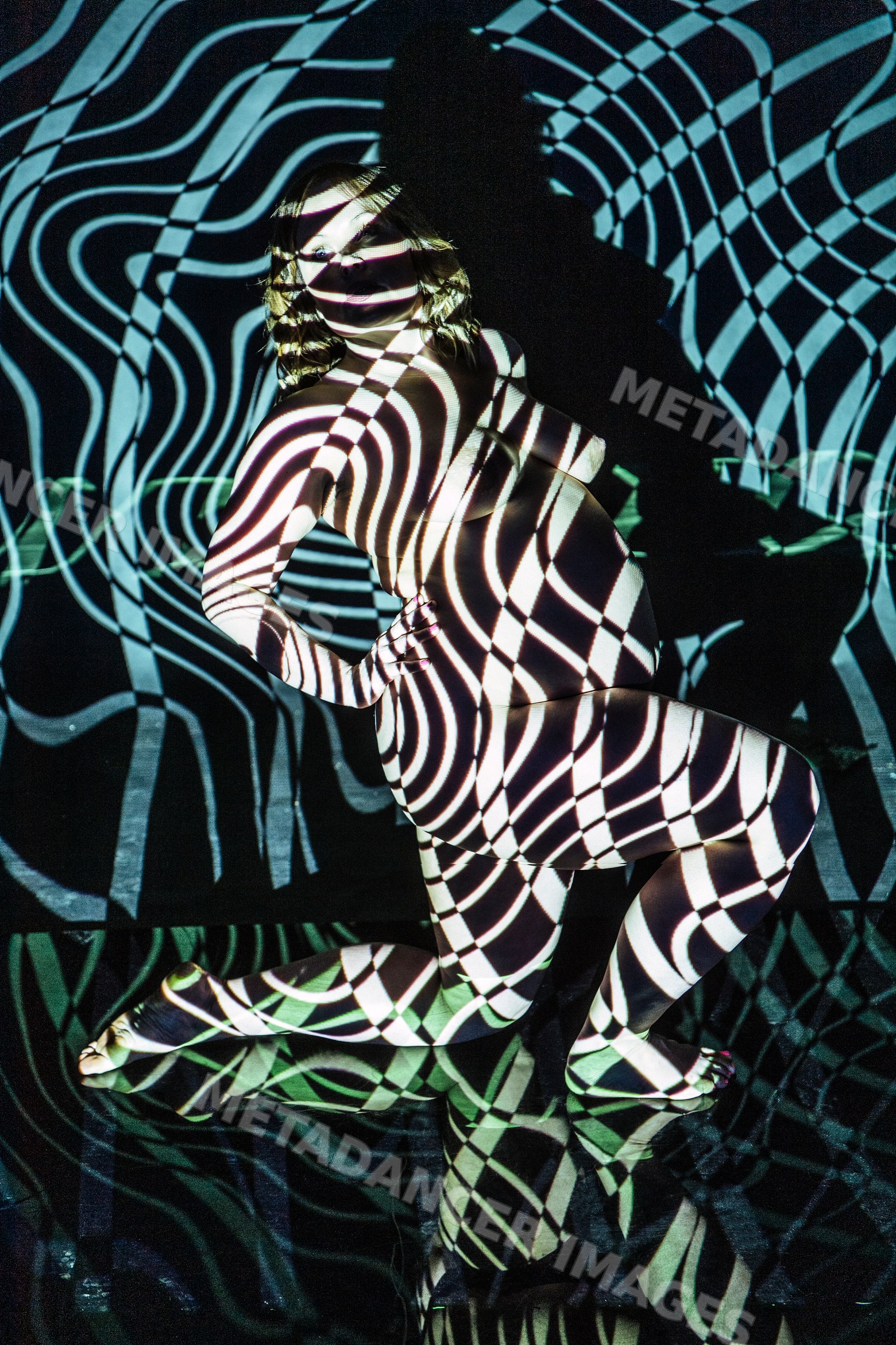 Pregnant woman posing nude with abstract black and white pattern