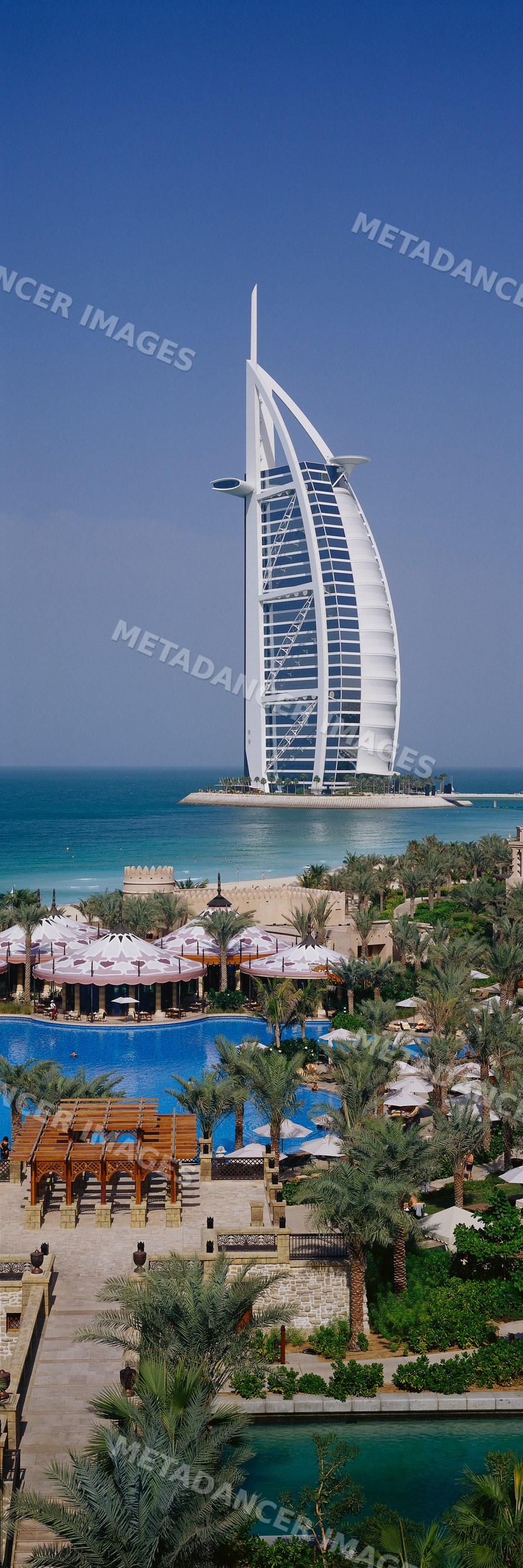 Burj al arab hotel on an island near dubai coastline with a resort