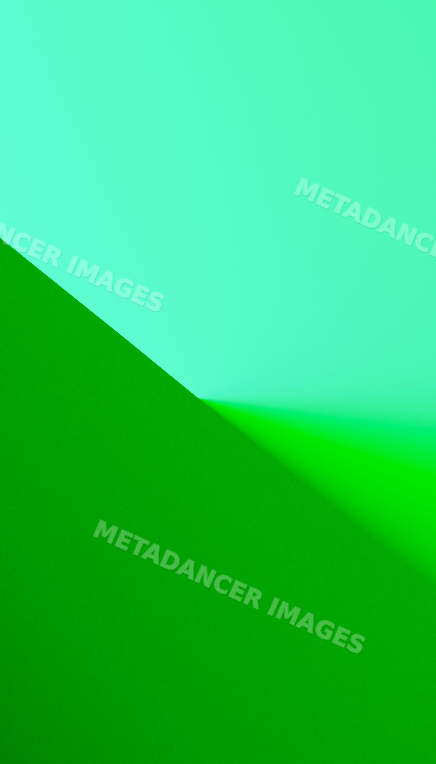 Close-up of textured green and blue papers meeting at an angled corner