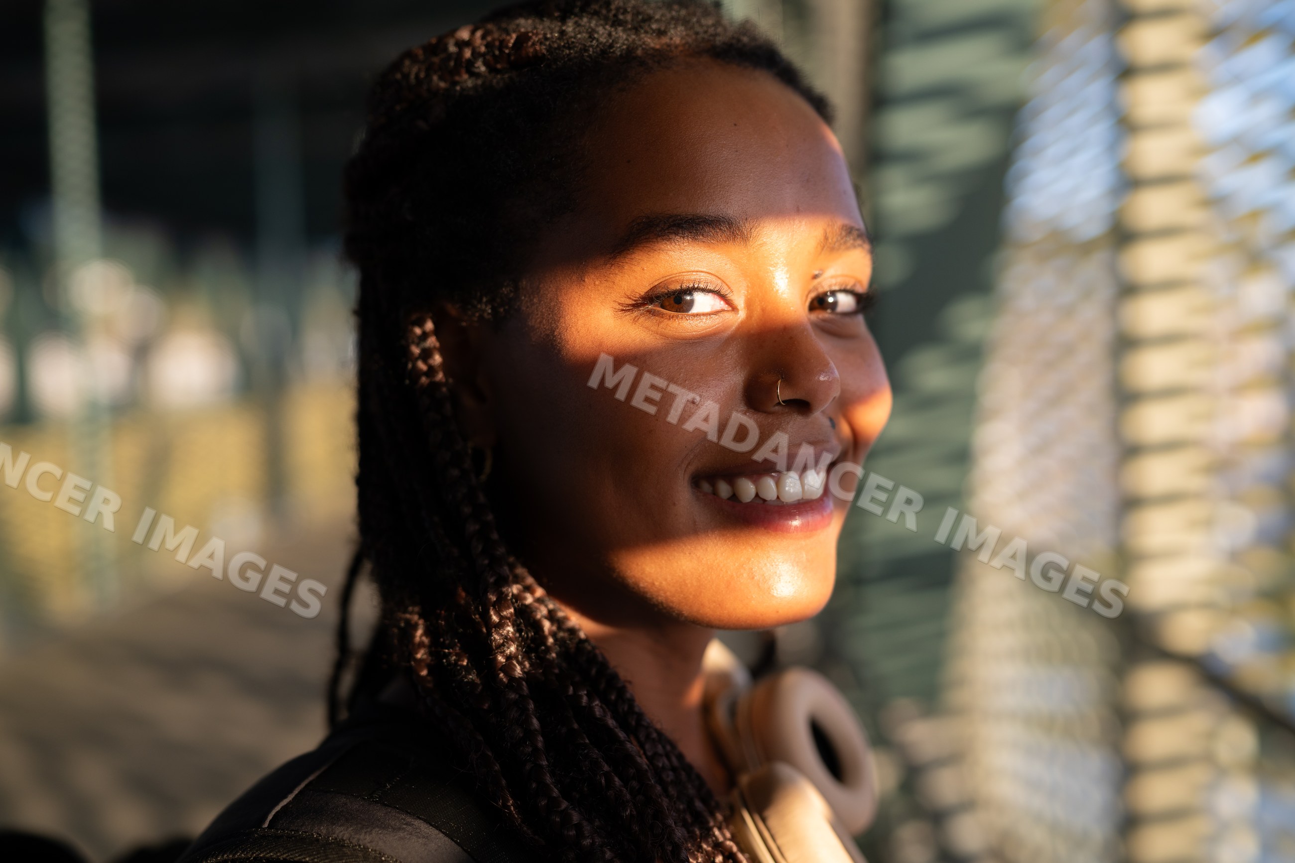 Young African American woman smiles warmly in natural sunlight