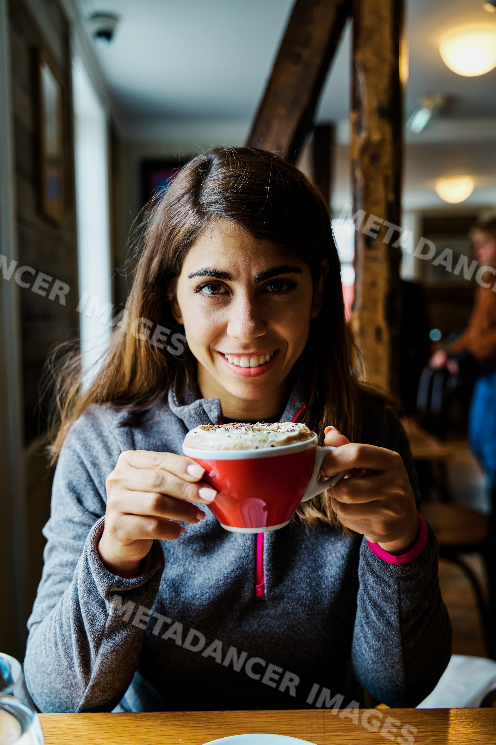 A white woman enjoys a cup of coffee in a cozy Iceland cafe