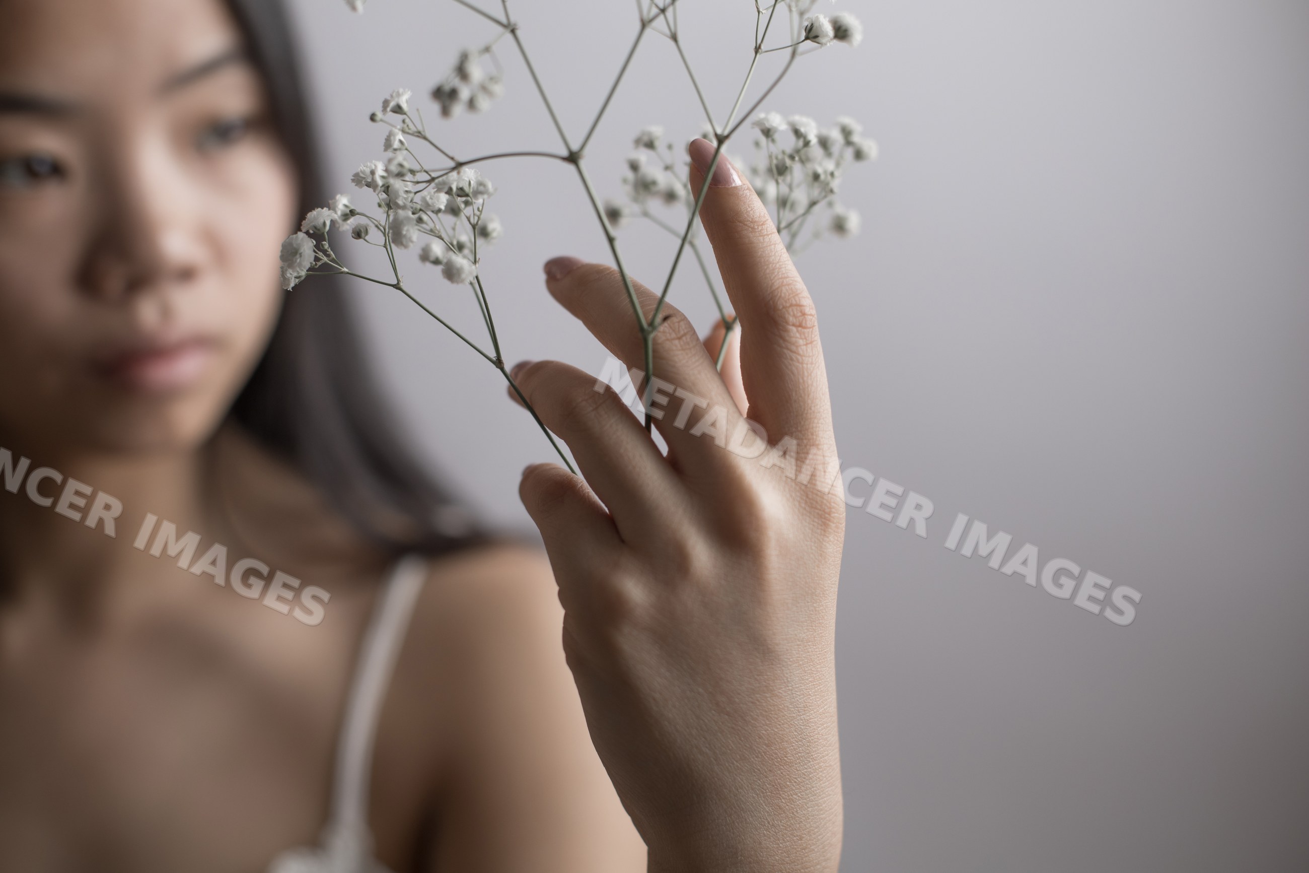 Southeast Asian woman holding delicate white flowers