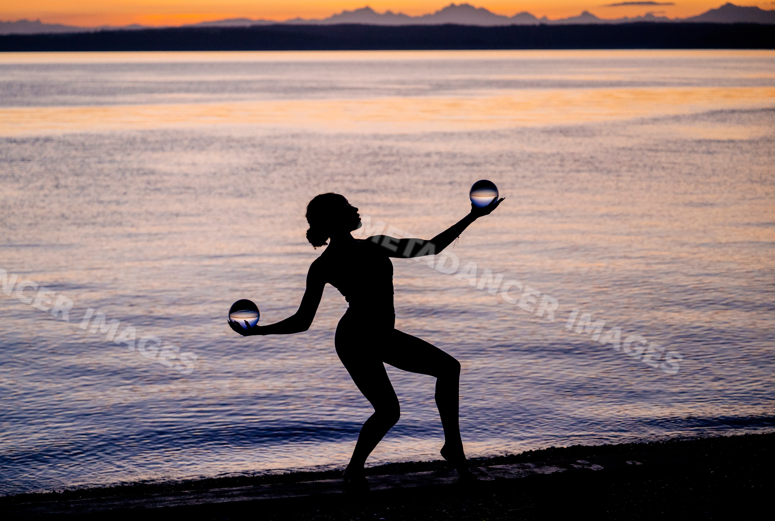 Hispanic woman silhouette balancing with glass balls
