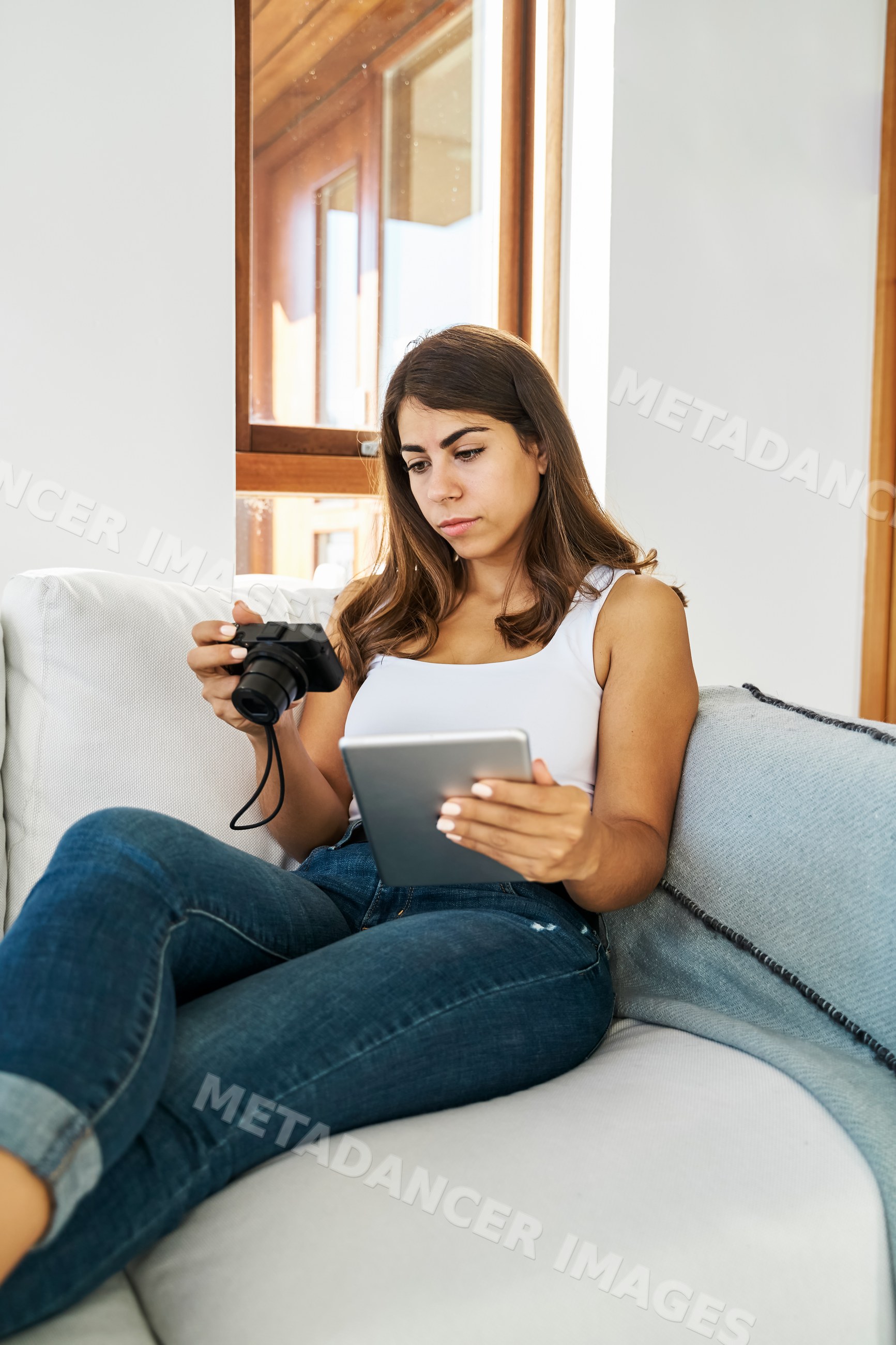 A white woman using a tablet and camera