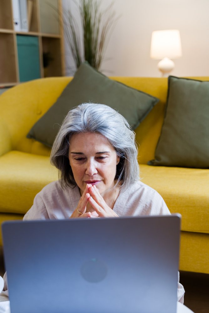 White woman with gray hair using laptop