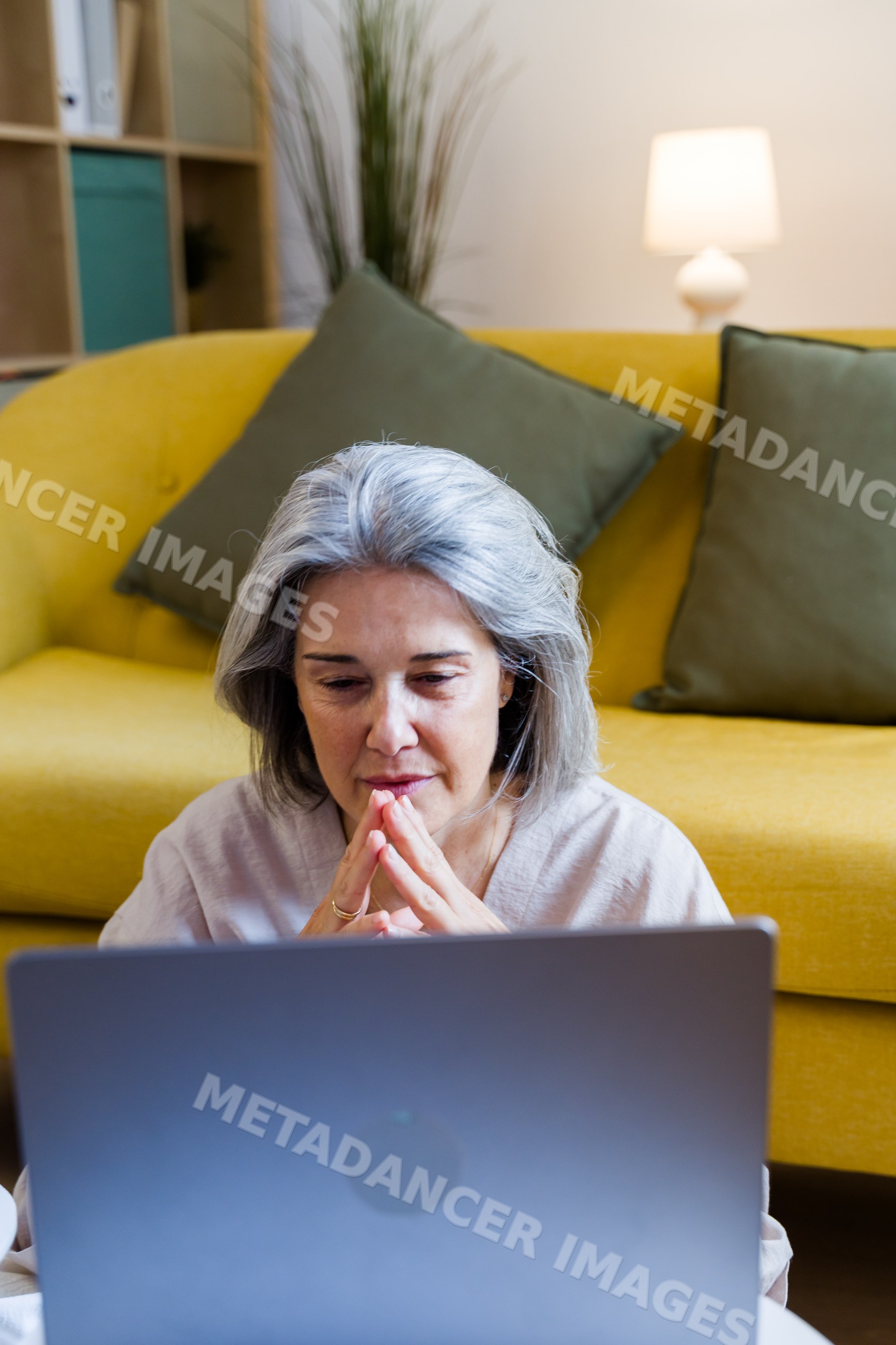 White woman with gray hair using laptop