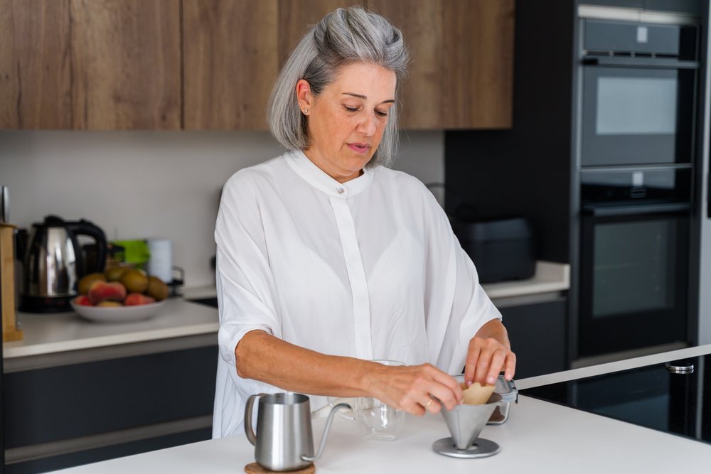 White Woman brewing coffee with pour over drip
