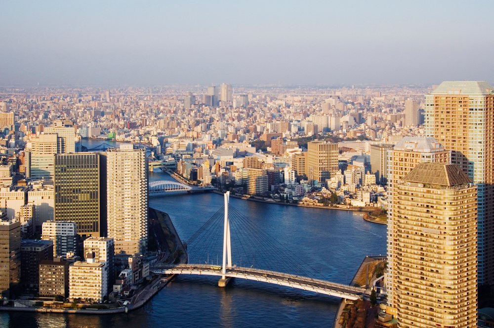 River and bridge crossing through urban tokyo cityscape