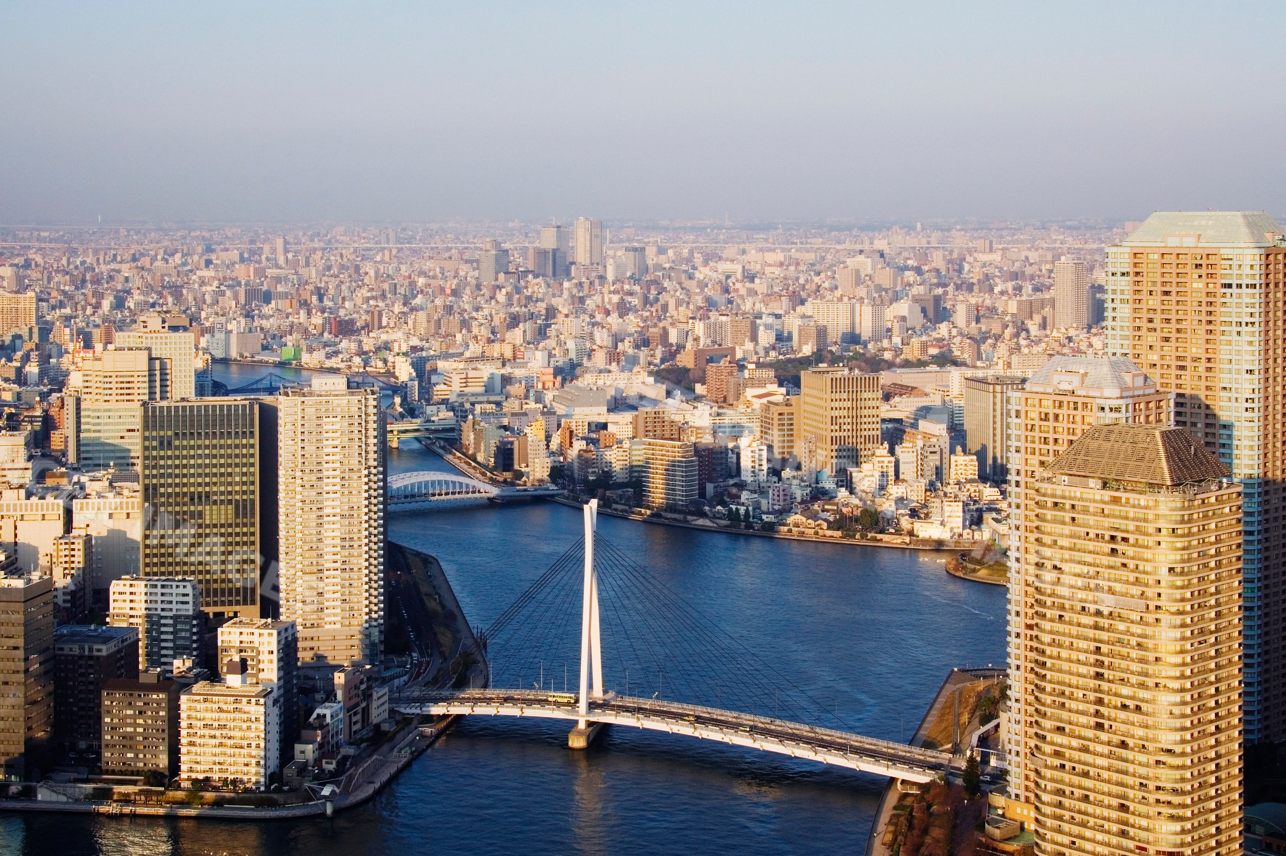 River and bridge crossing through urban tokyo cityscape