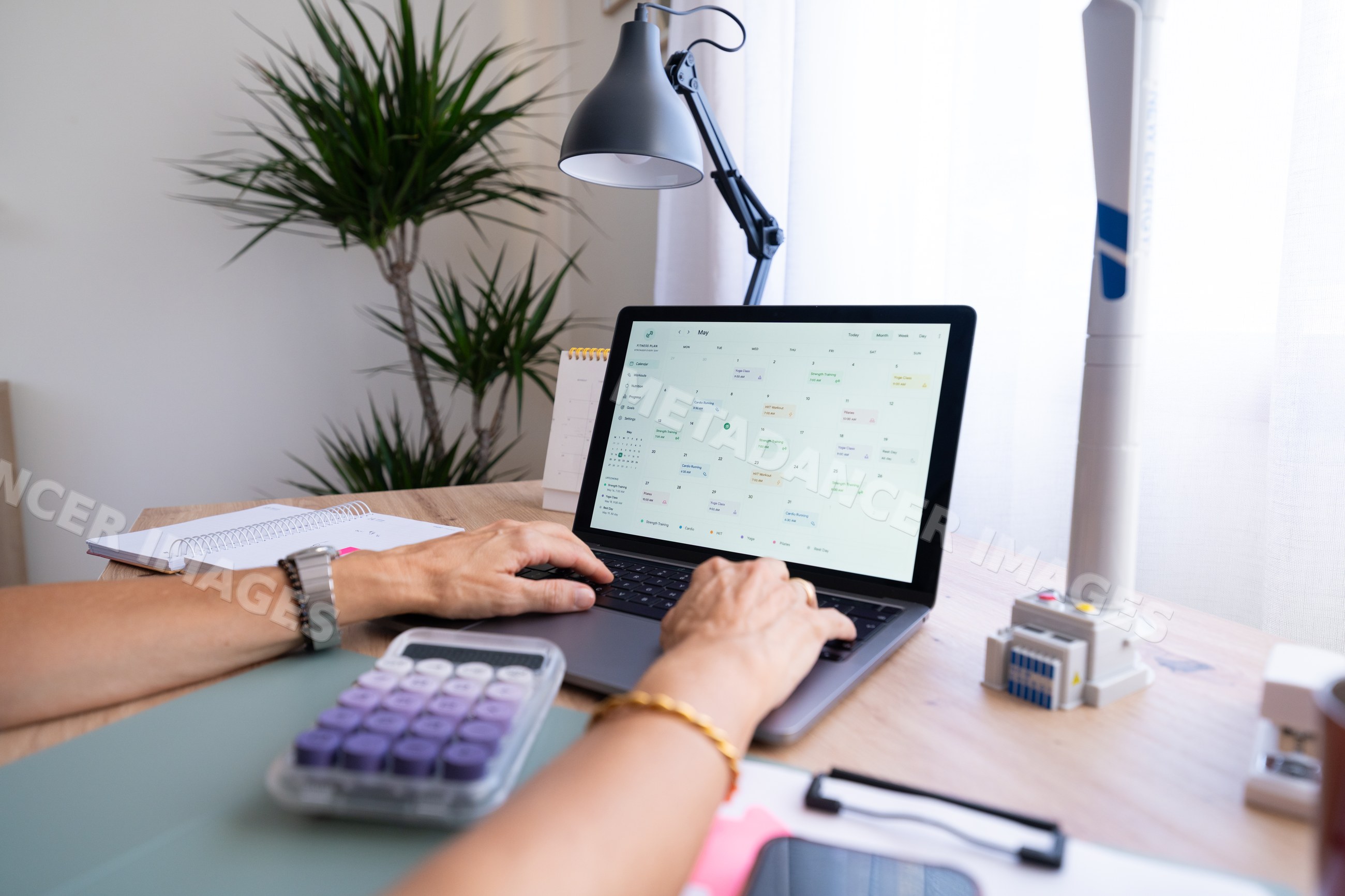 White person using laptop with calendar app in home workspace