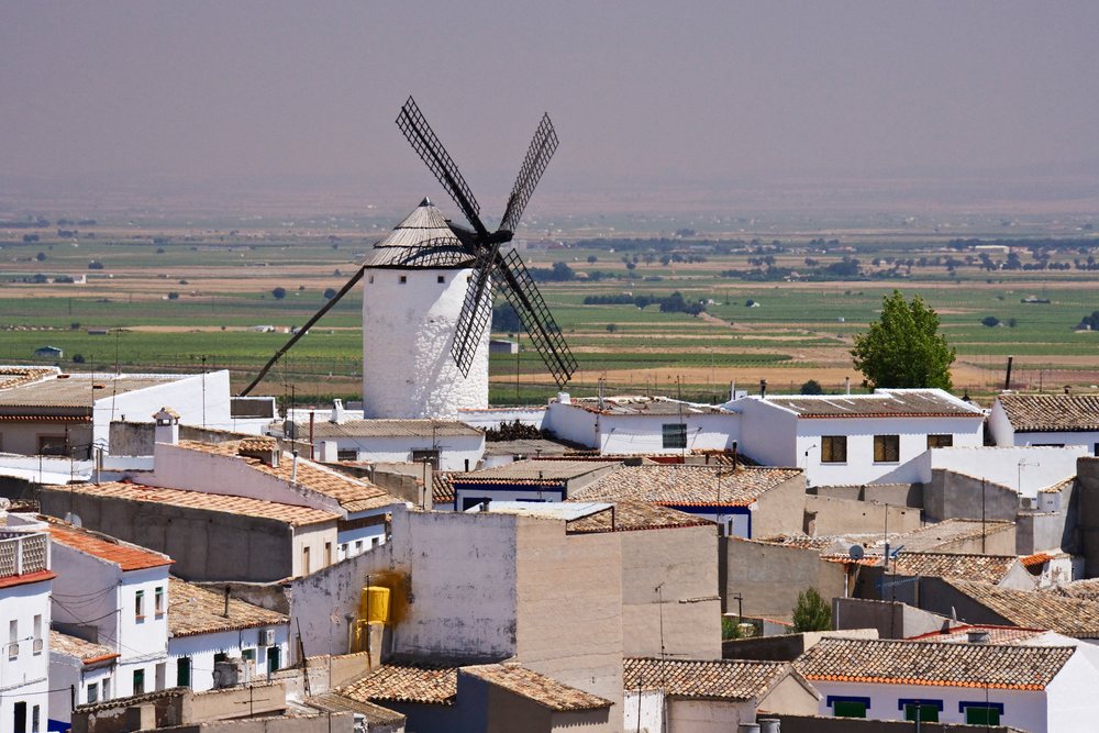 Windmill above rooftops in rural la mancha village